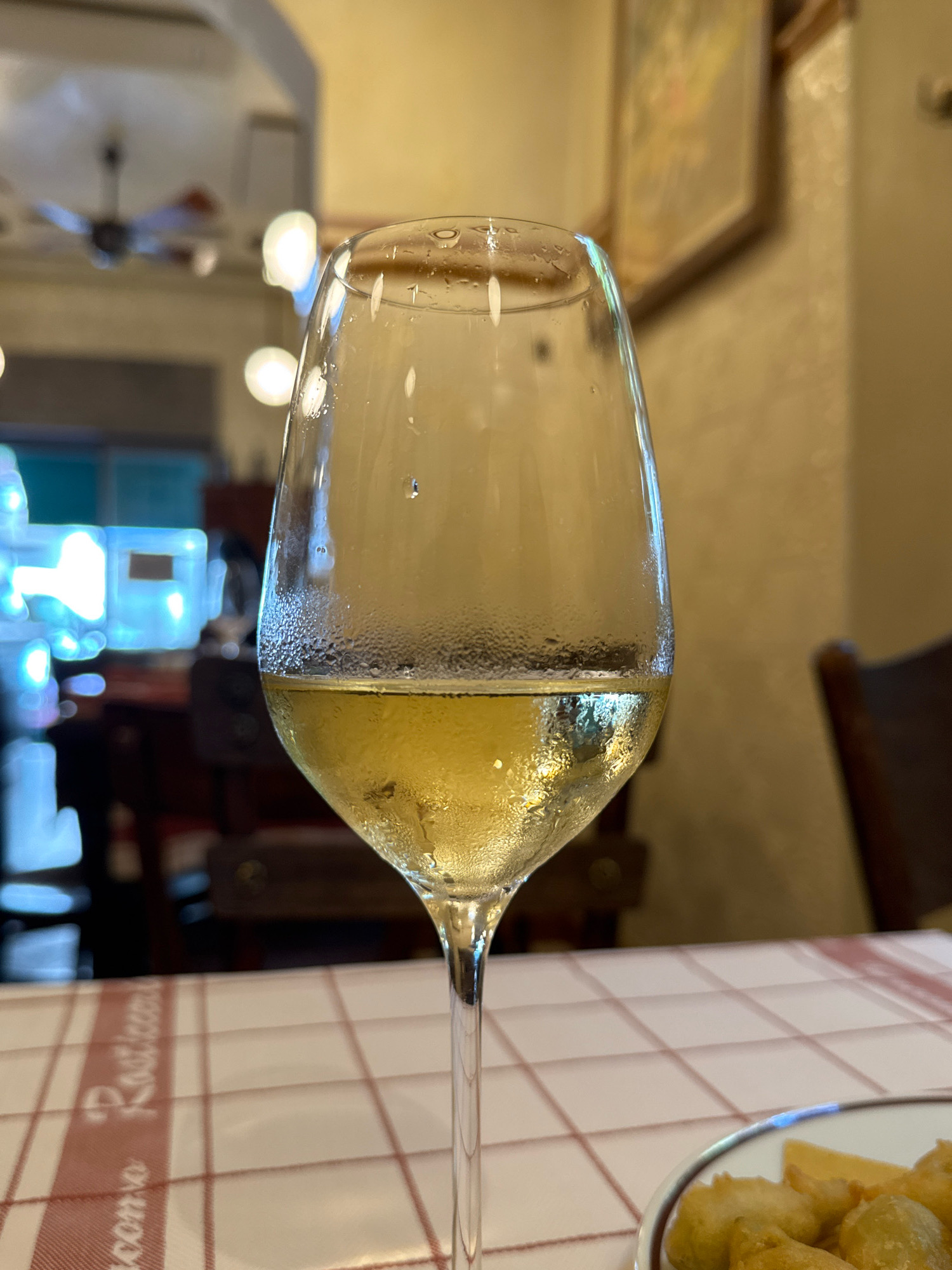 Fried zucchini flowers and white wine at a Milan table