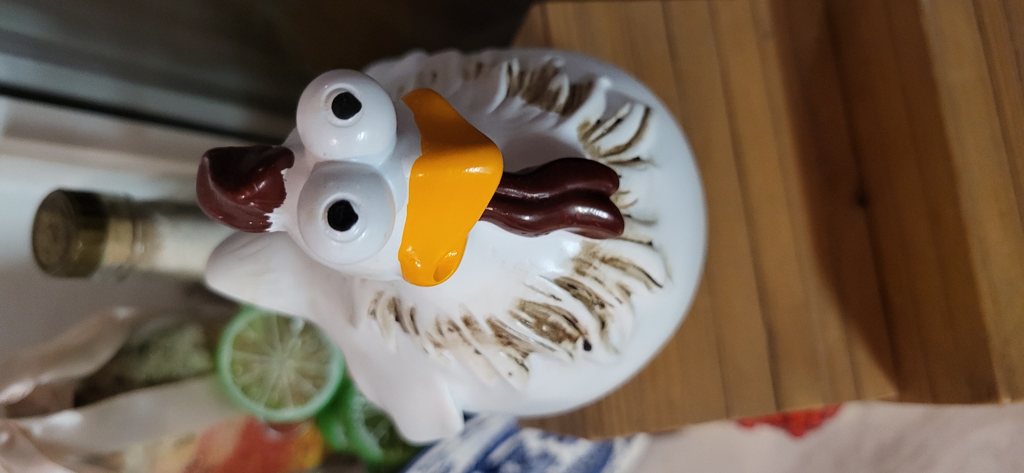 Quirky ceramic chicken figurine on a wooden surface, Almaty