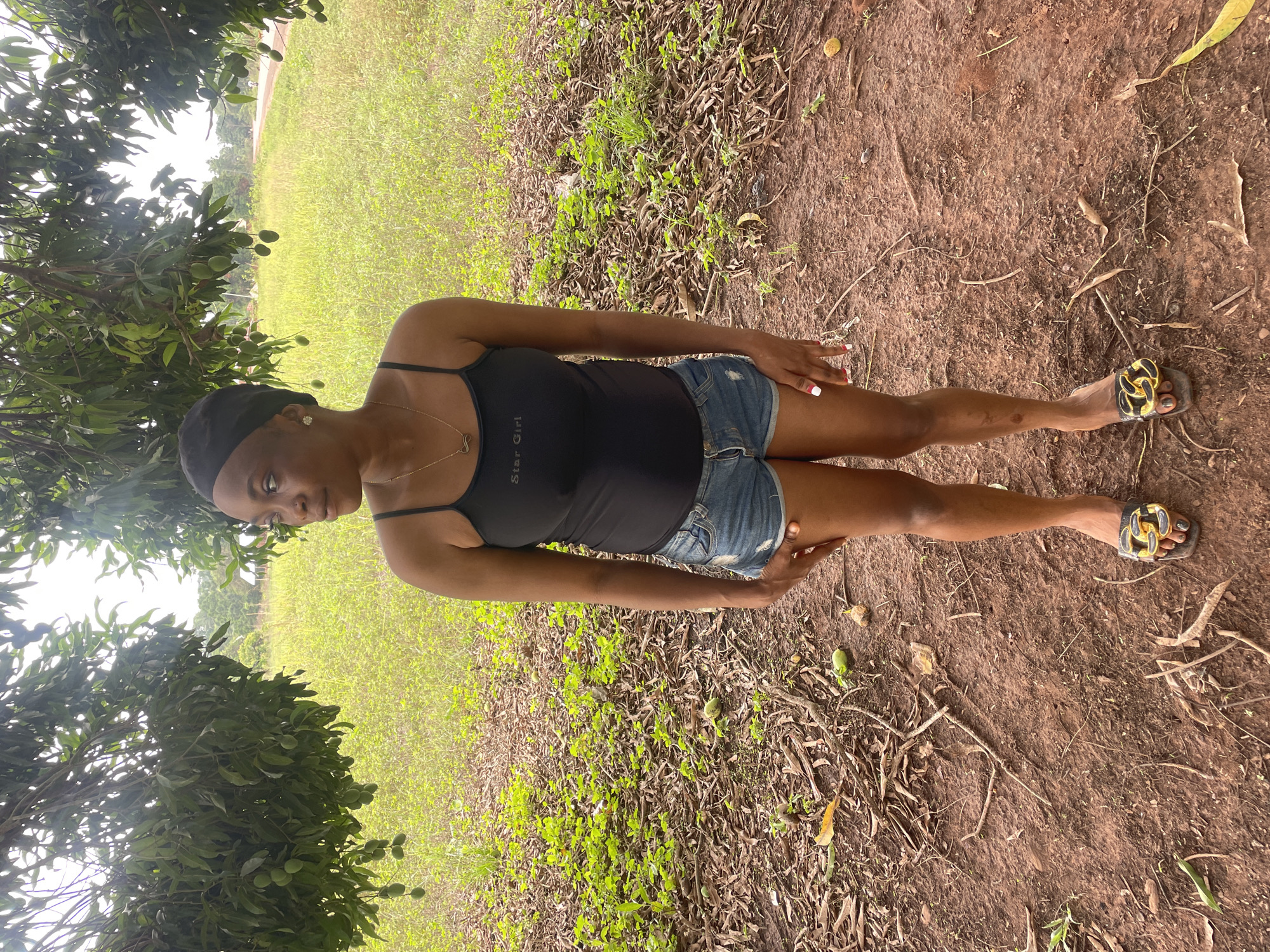 Woman in 'Star Girl' tank top observed outdoors in Ogpe, Nigeria