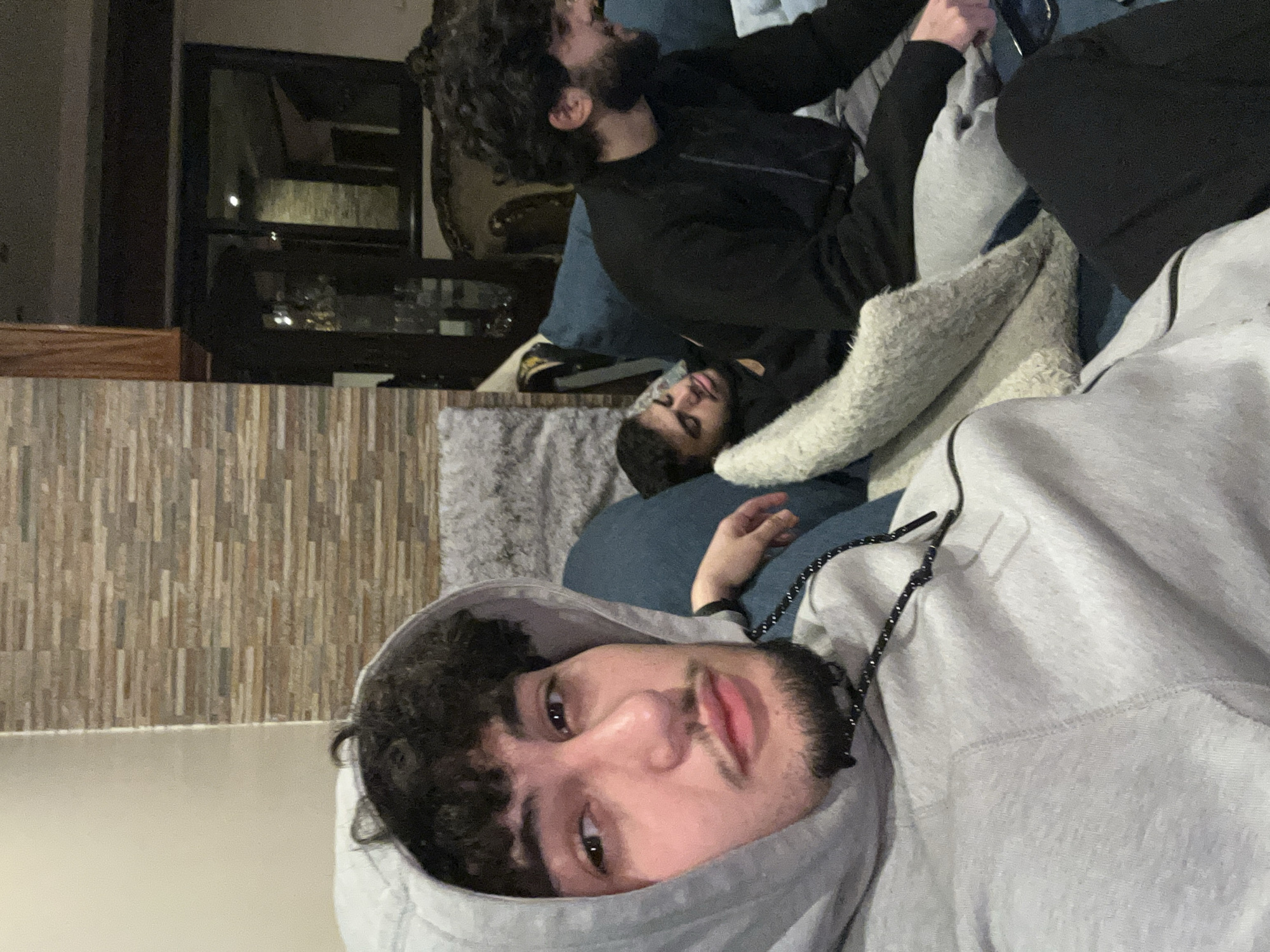 Young men spend casual evening with phones, cat in Syria
