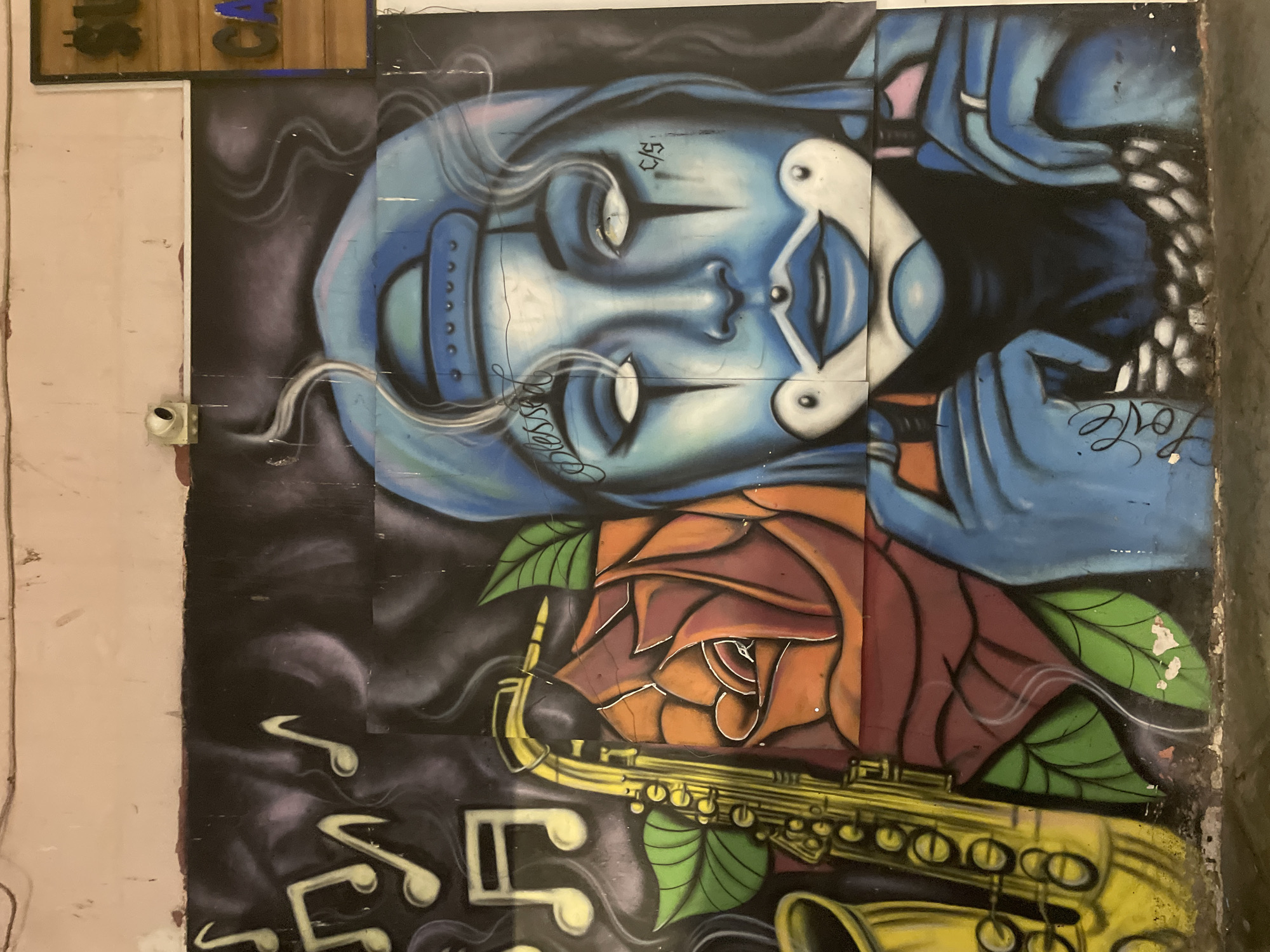 Street murals and mosaics mix styles on a single urban block