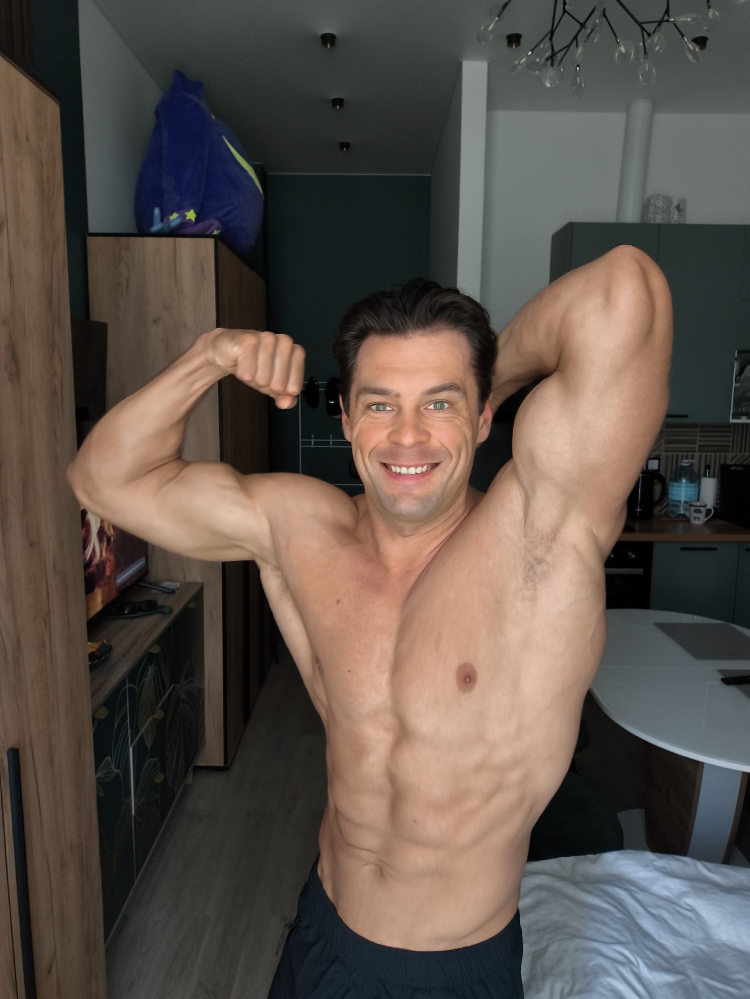 Muscular man poses shirtless in Moscow apartment morning