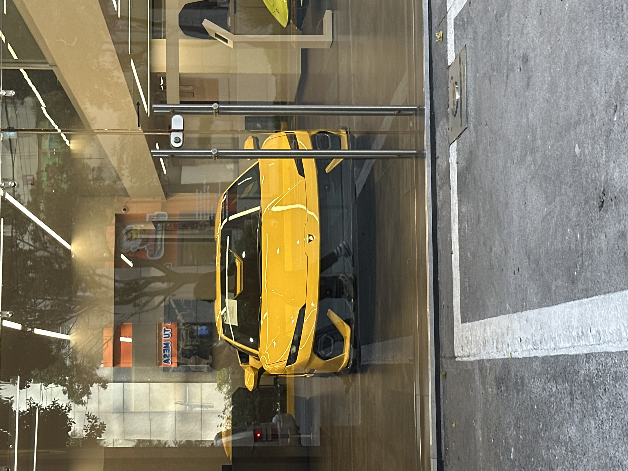Yellow Lamborghini displayed behind glass window in Mexico City