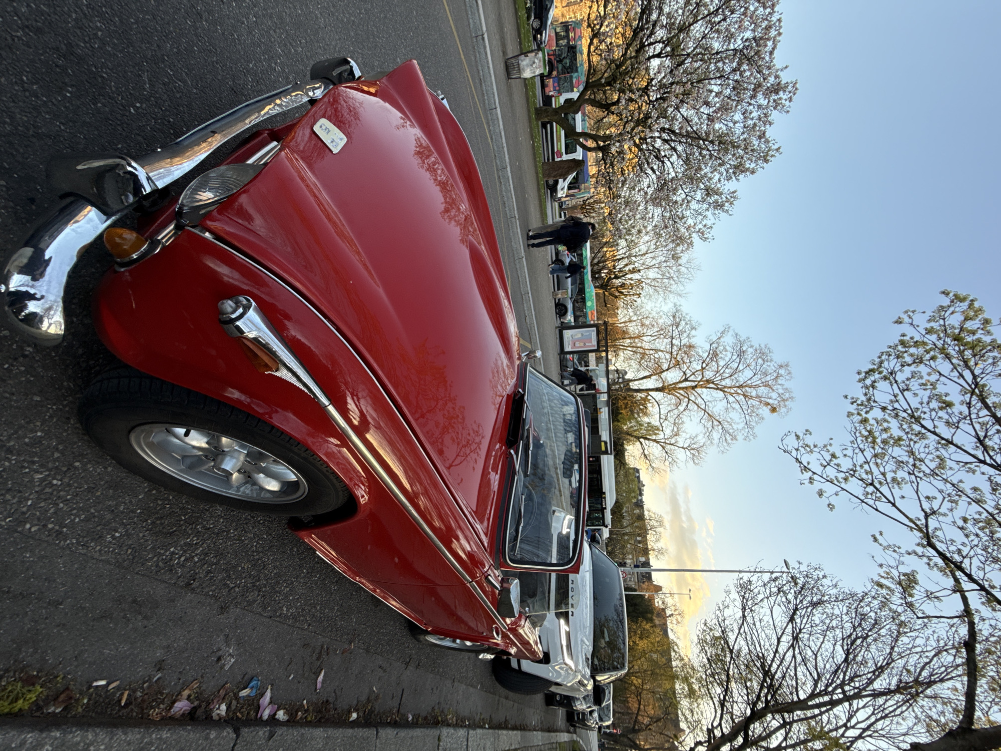Man tours Strasbourg landmarks with vintage red Triumph convertible