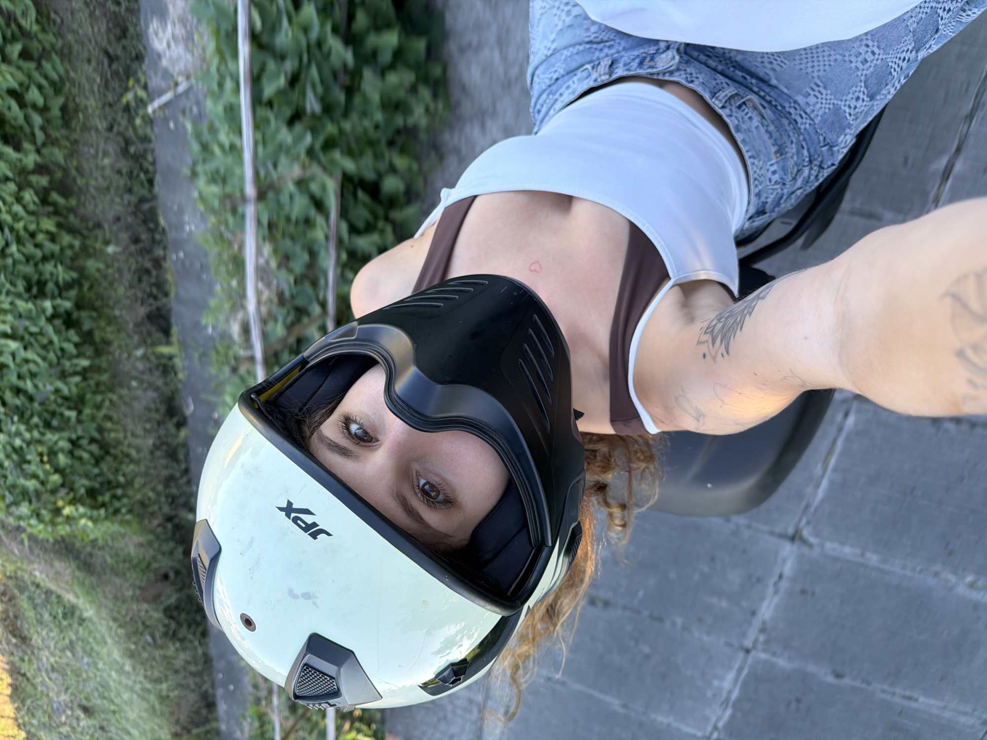 Woman in JPX helmet takes selfies near motorcycle in North Kuta