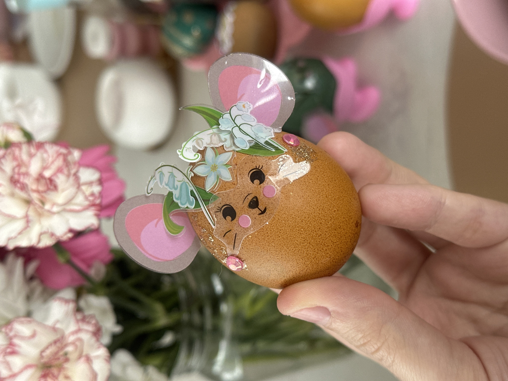 Person displays mouse-decorated Easter egg in Kharnavy, Russia