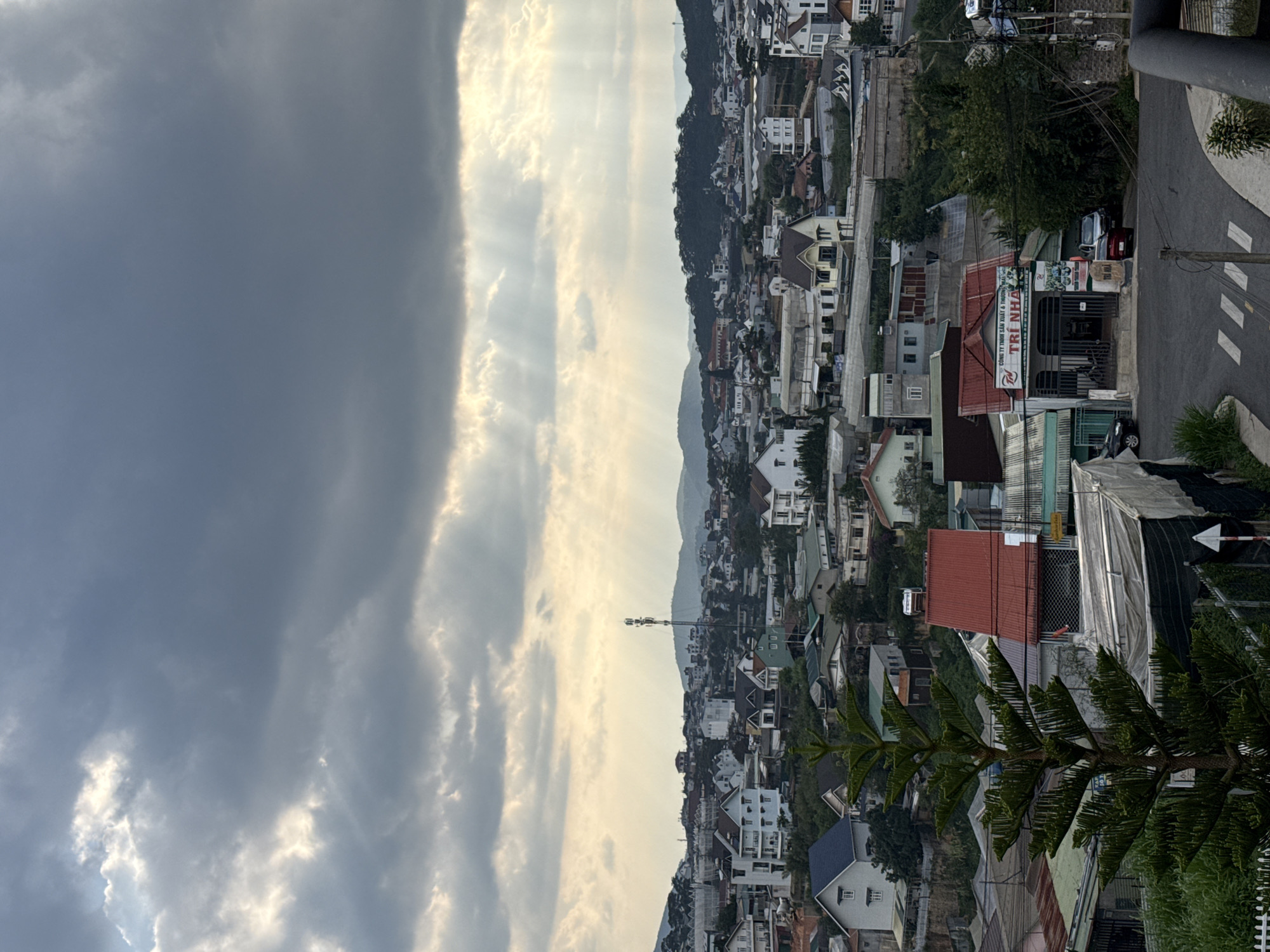Dramatic sunbeams pierce storm clouds over Đà Lạt, Vietnam