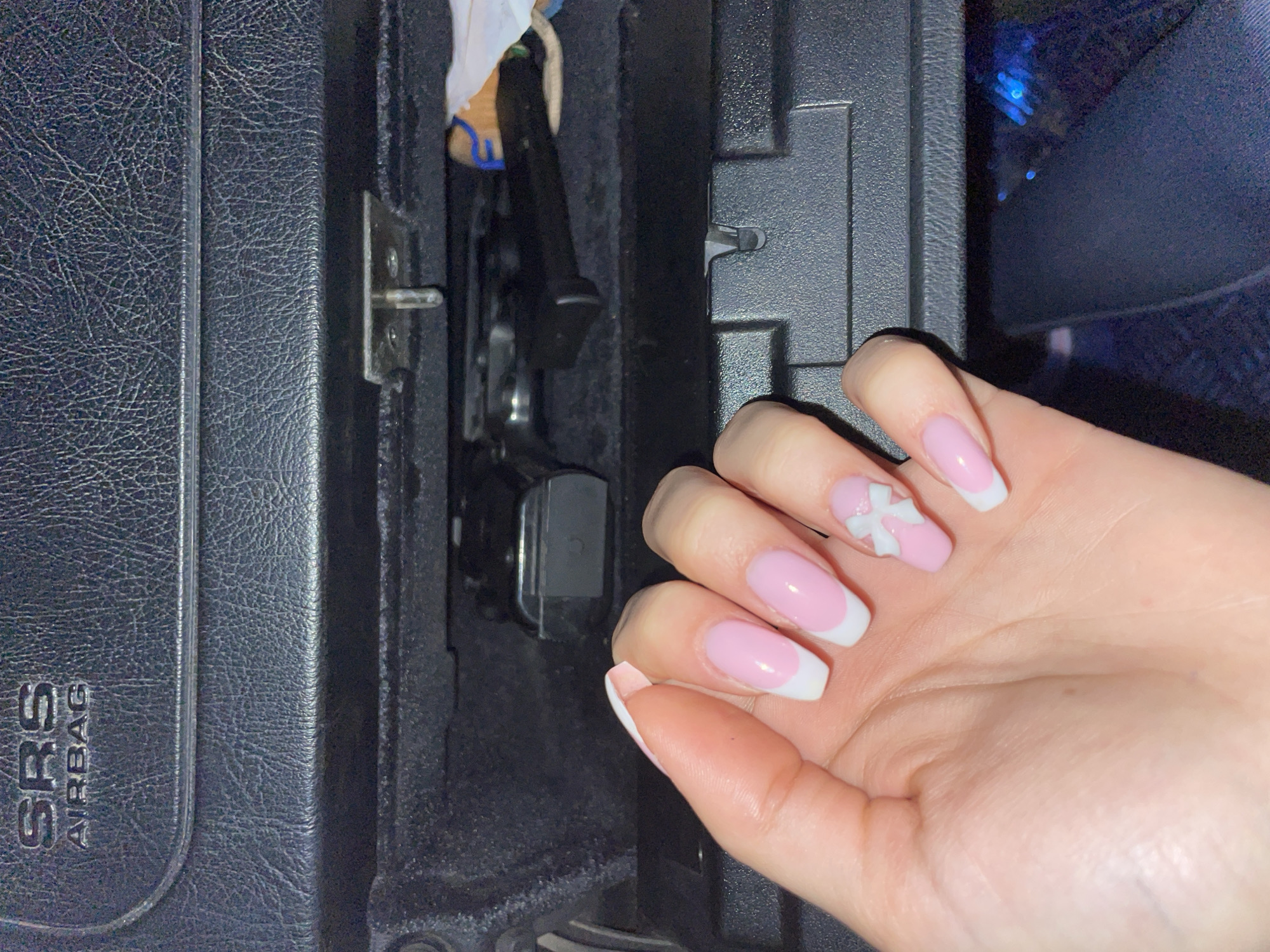 Manicured hand with decorative nails photographed in car interior