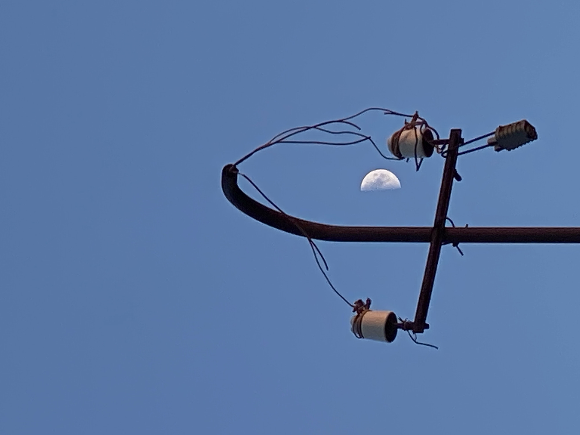 Sunset, moon, and utility poles fill the Cairaclia sky