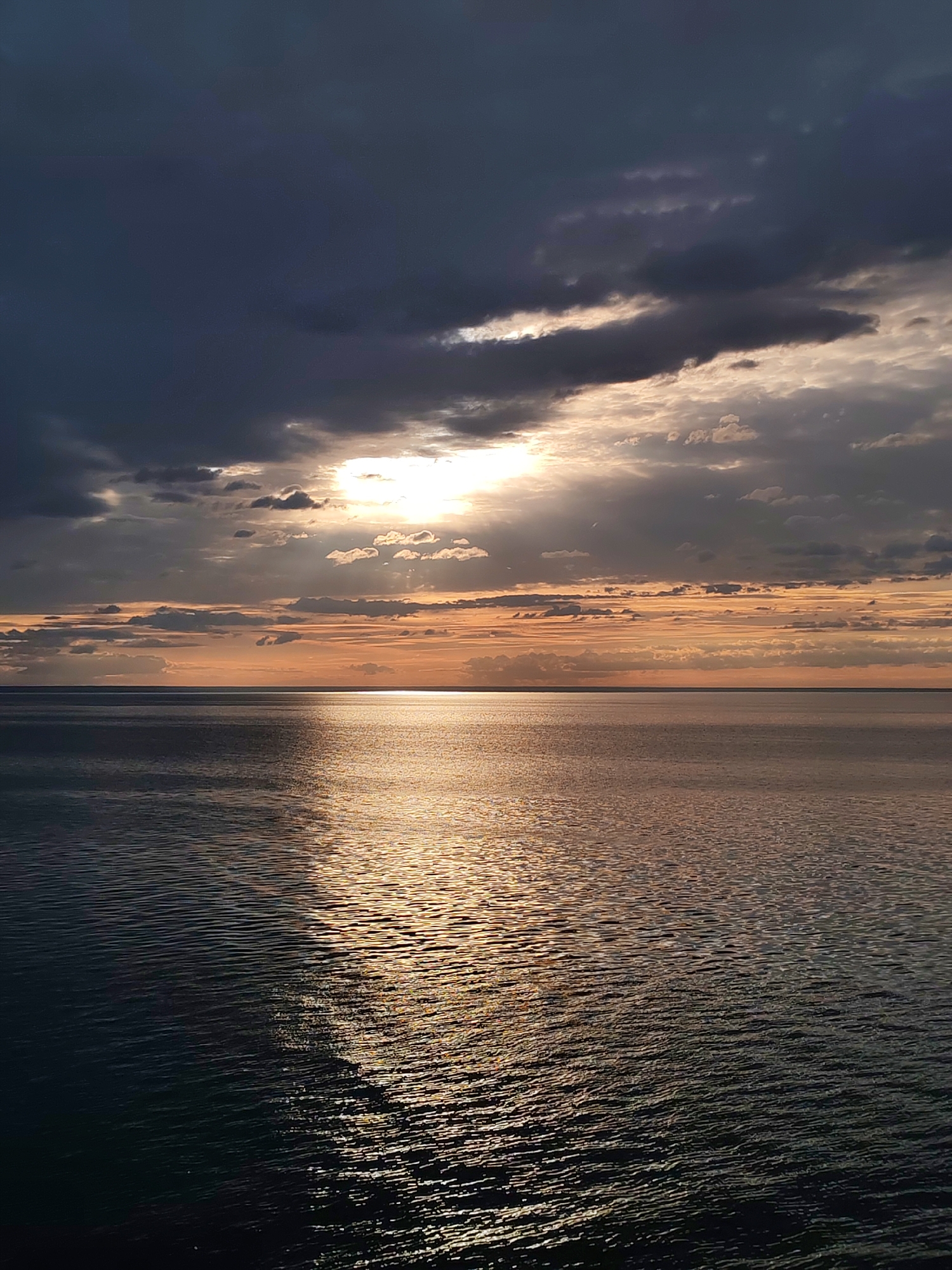 Dramatic sky with sunlight breaks through clouds over Russian waters