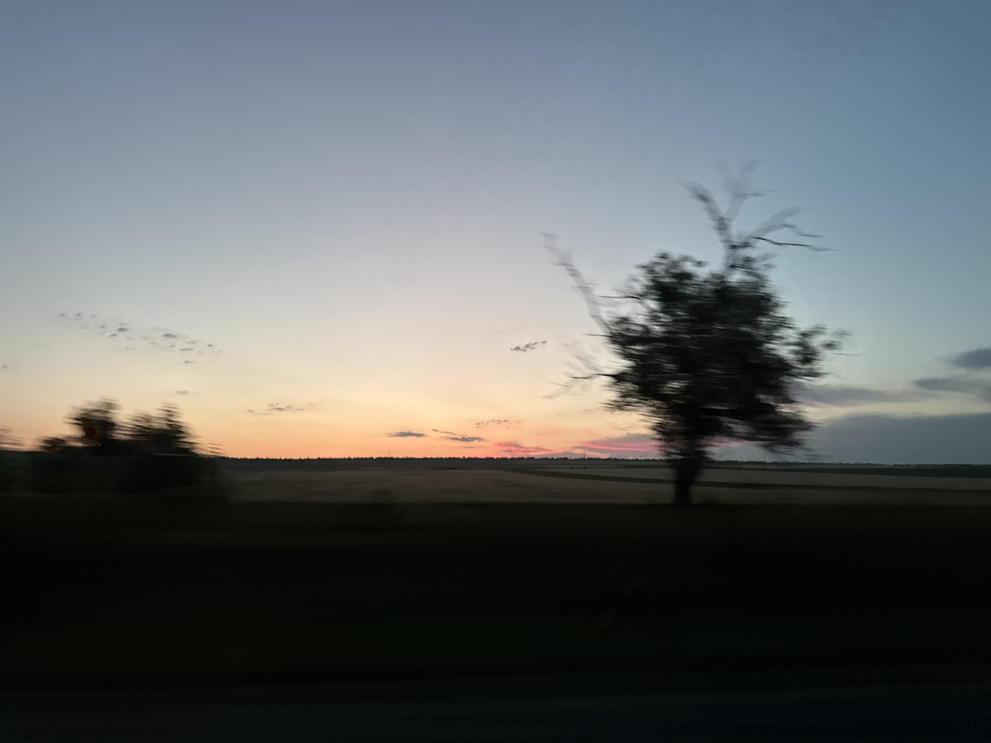 Evening road trip through open countryside at sunset
