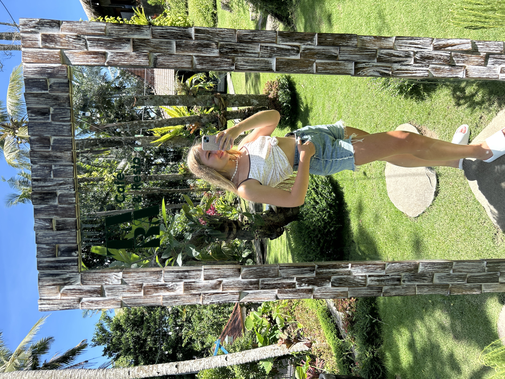 Woman takes mirror selfies at tropical garden in Gianyar