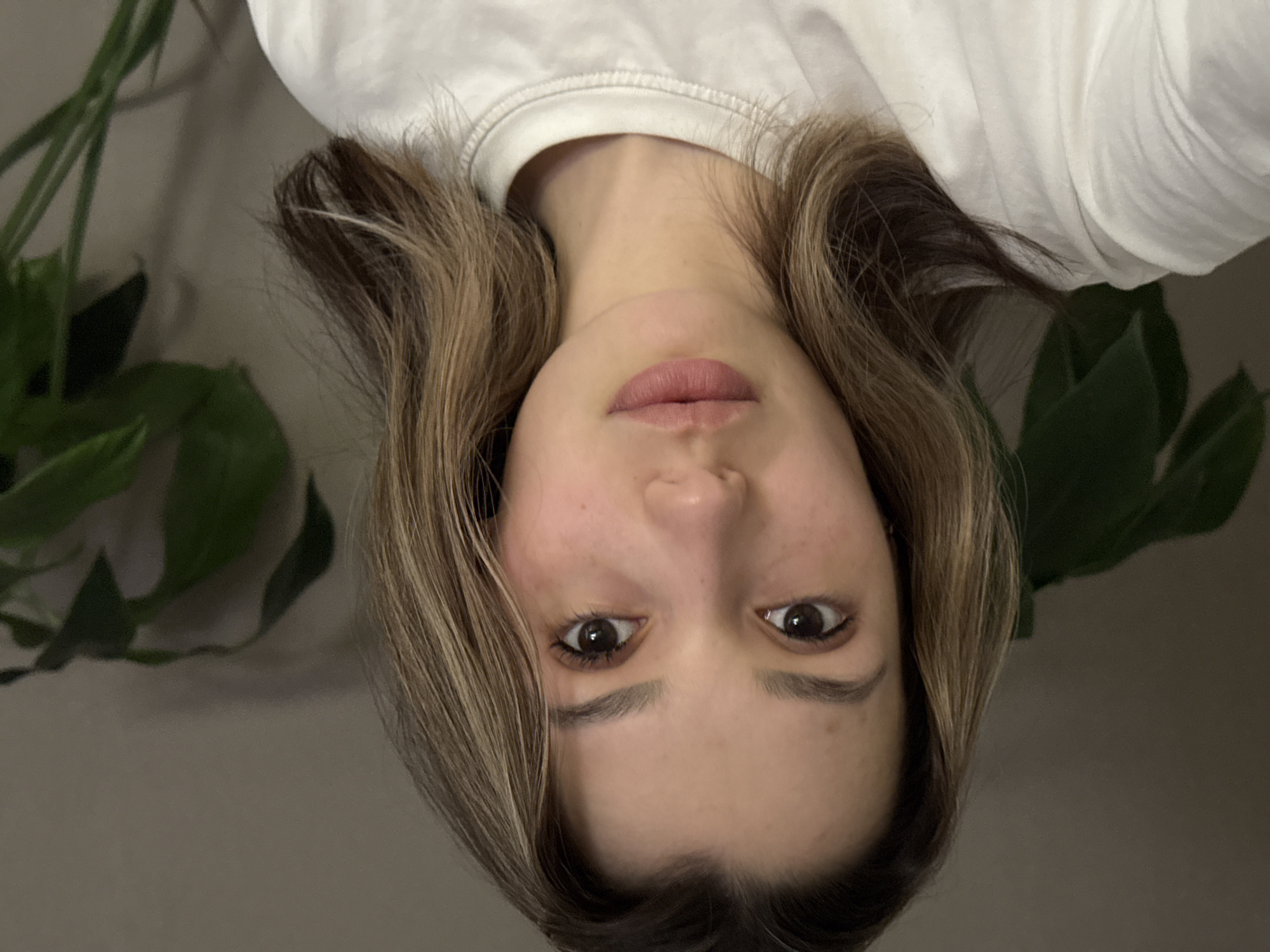 Young woman captures multiple selfie portraits indoors Tuesday afternoon