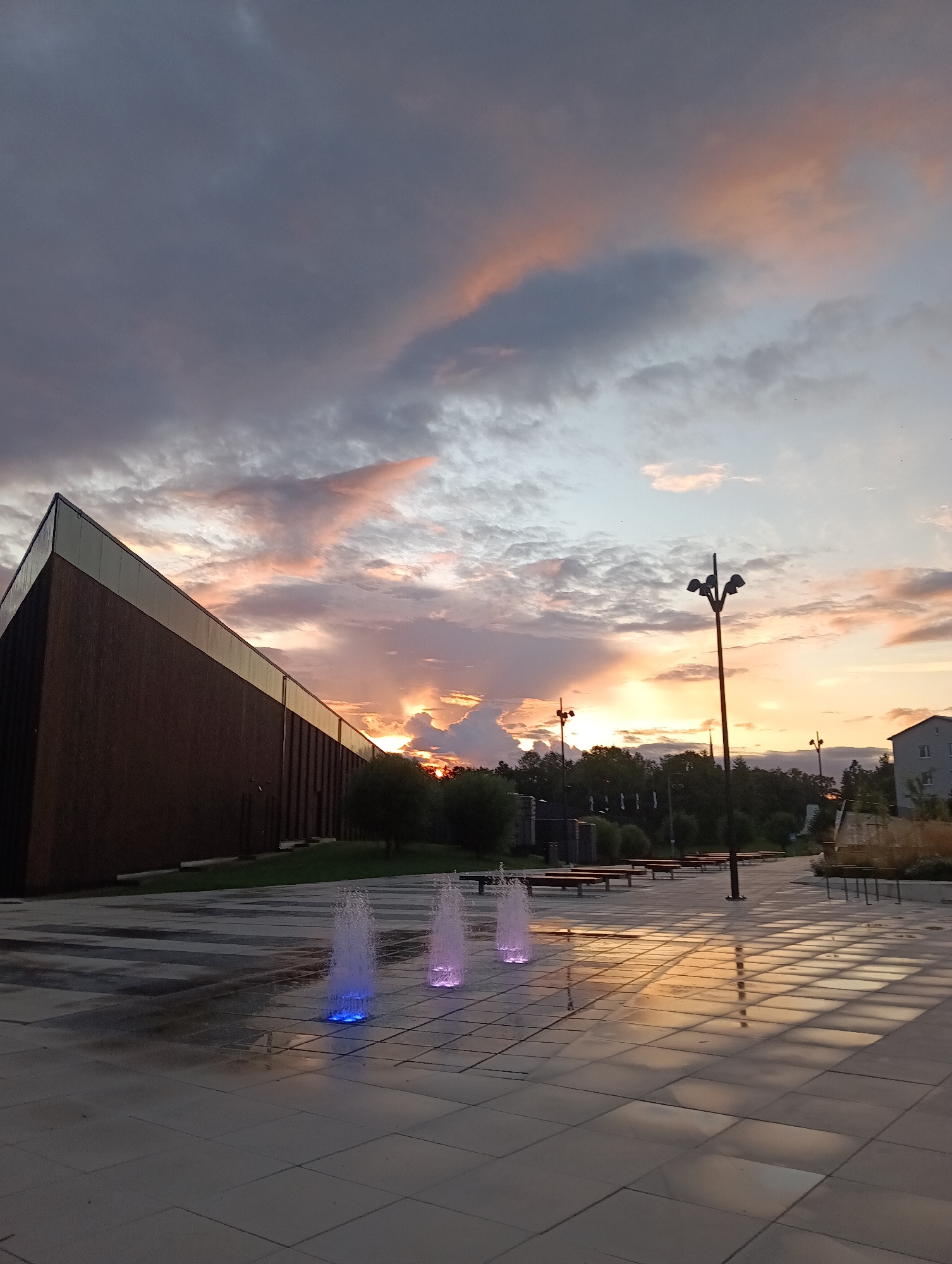 Sunset colors wash over an urban plaza and park