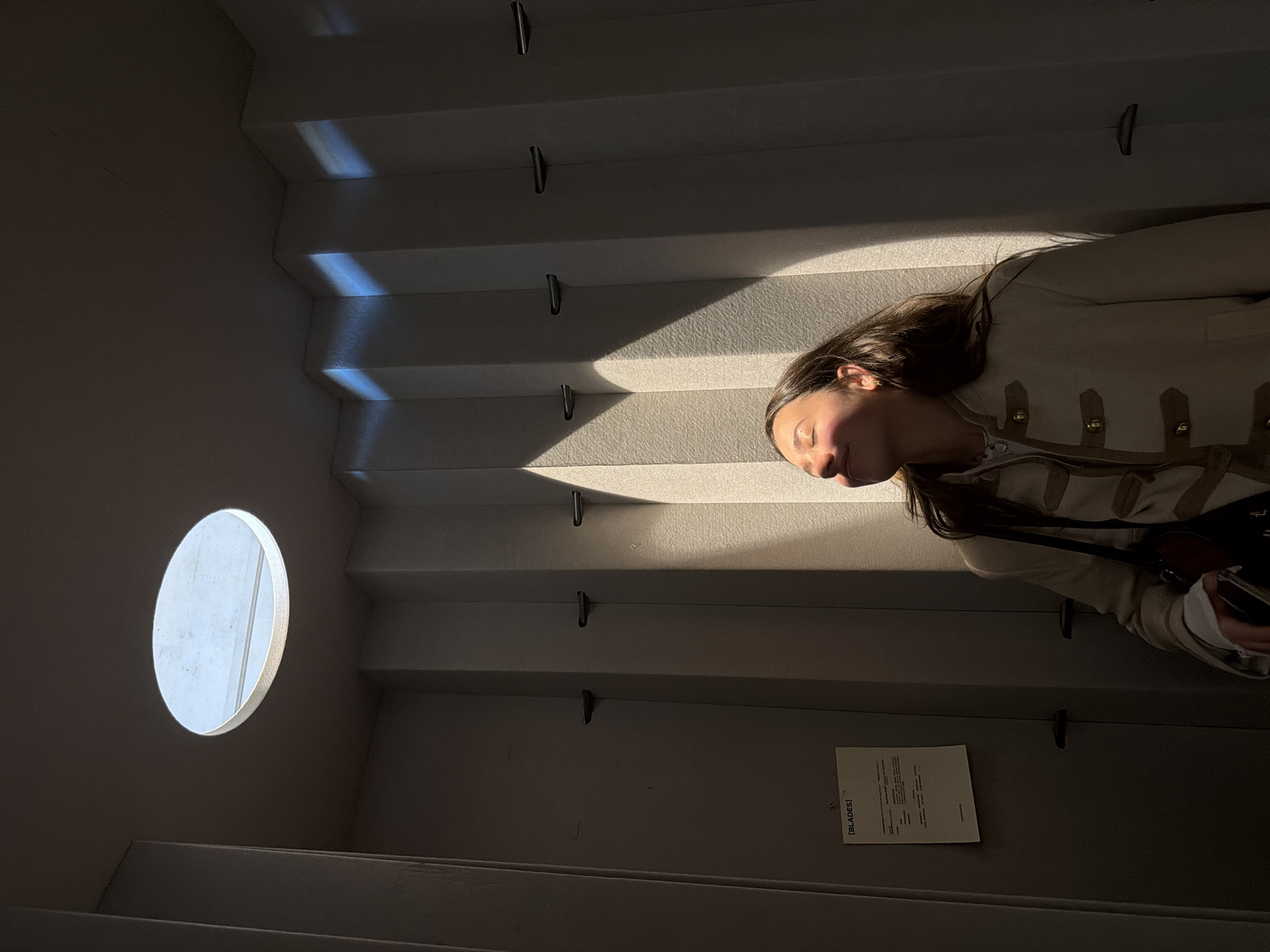 Woman photographed on sunlit staircase in minimalist setting