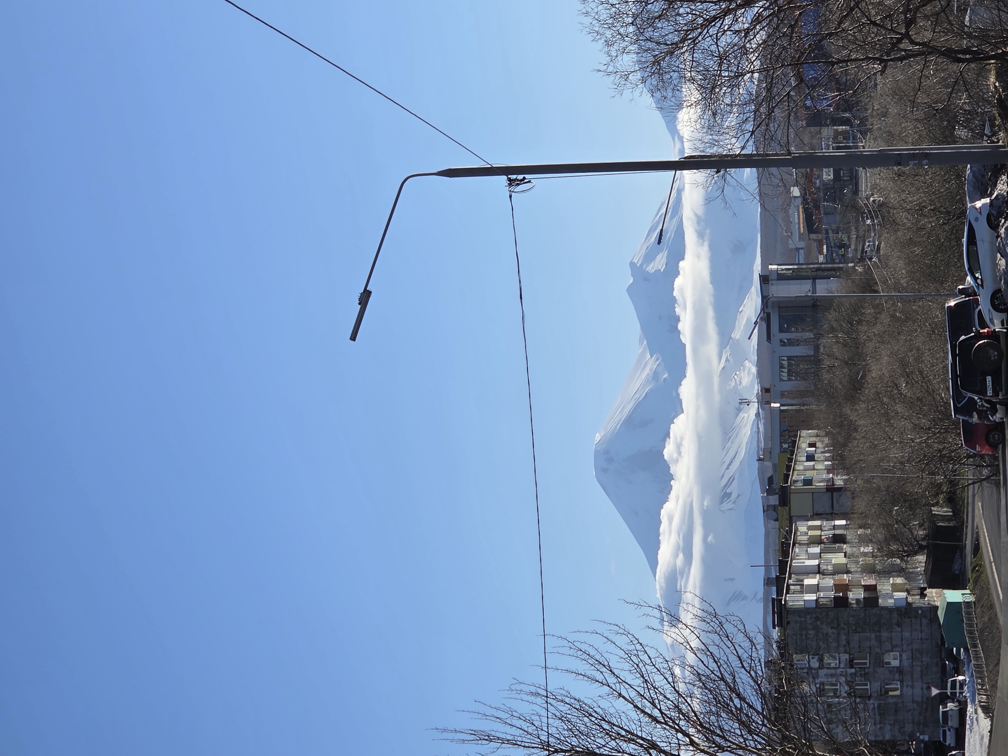 Coastal city with ships and snow-capped mountains documented