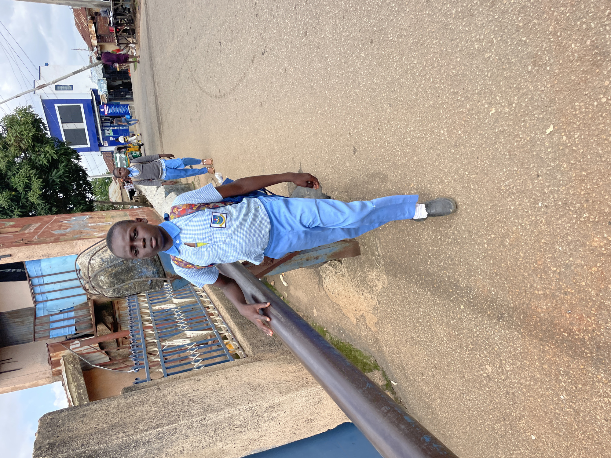 Street scene with multiple people on a paved road in Jos