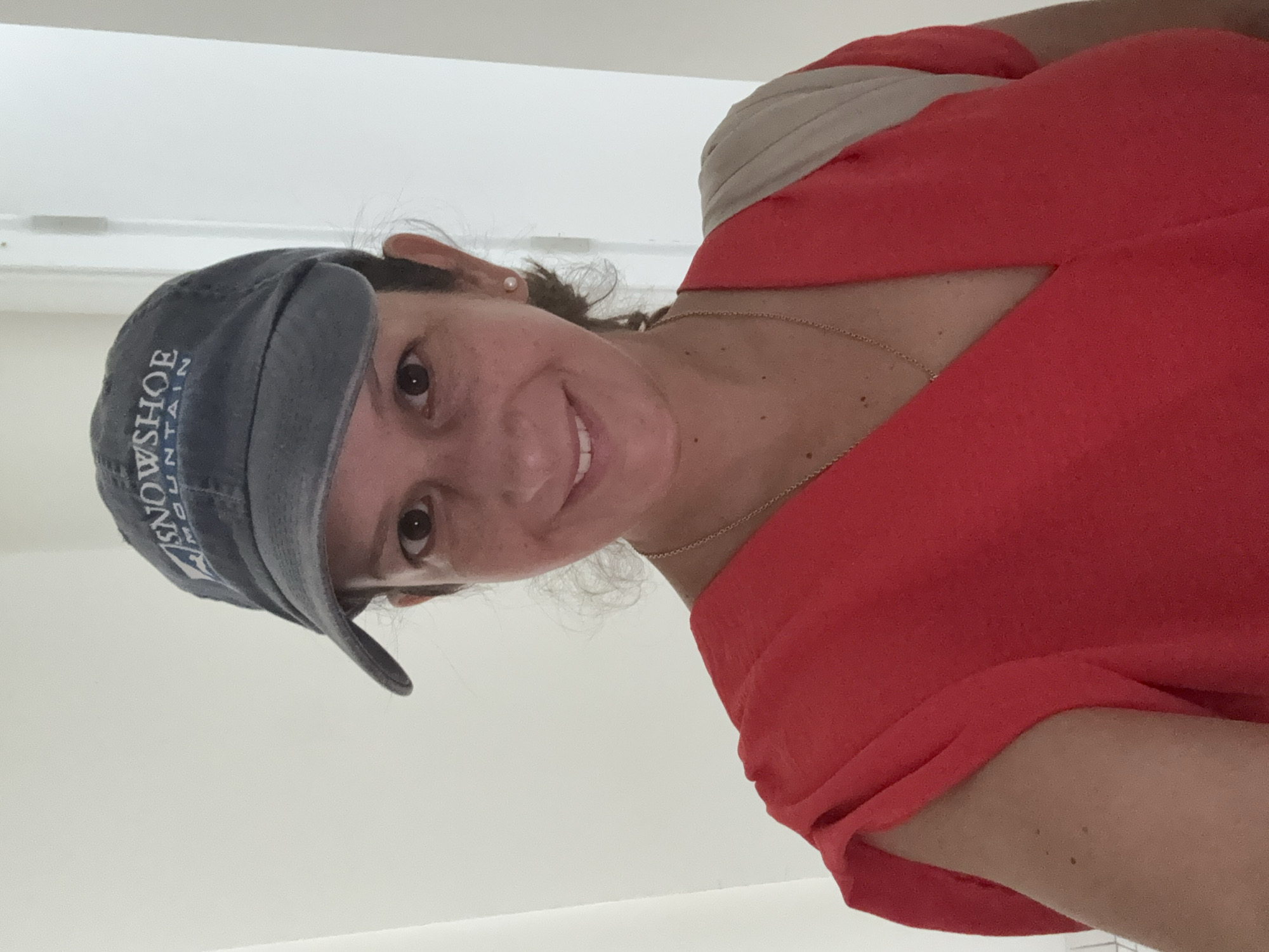 Woman in baseball cap photographed smiling in Ancón, Peru