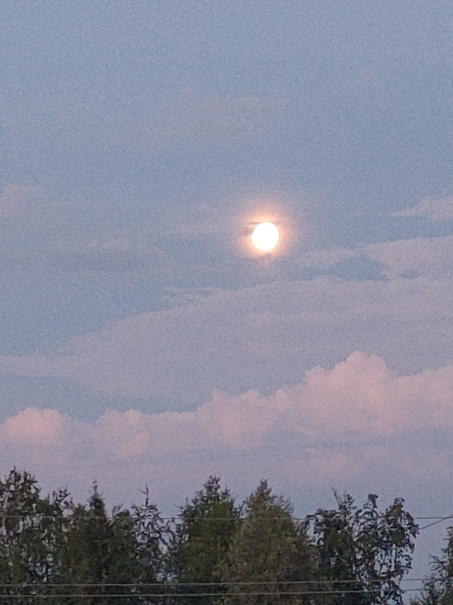 Full moon rises through wispy clouds over western Siberia