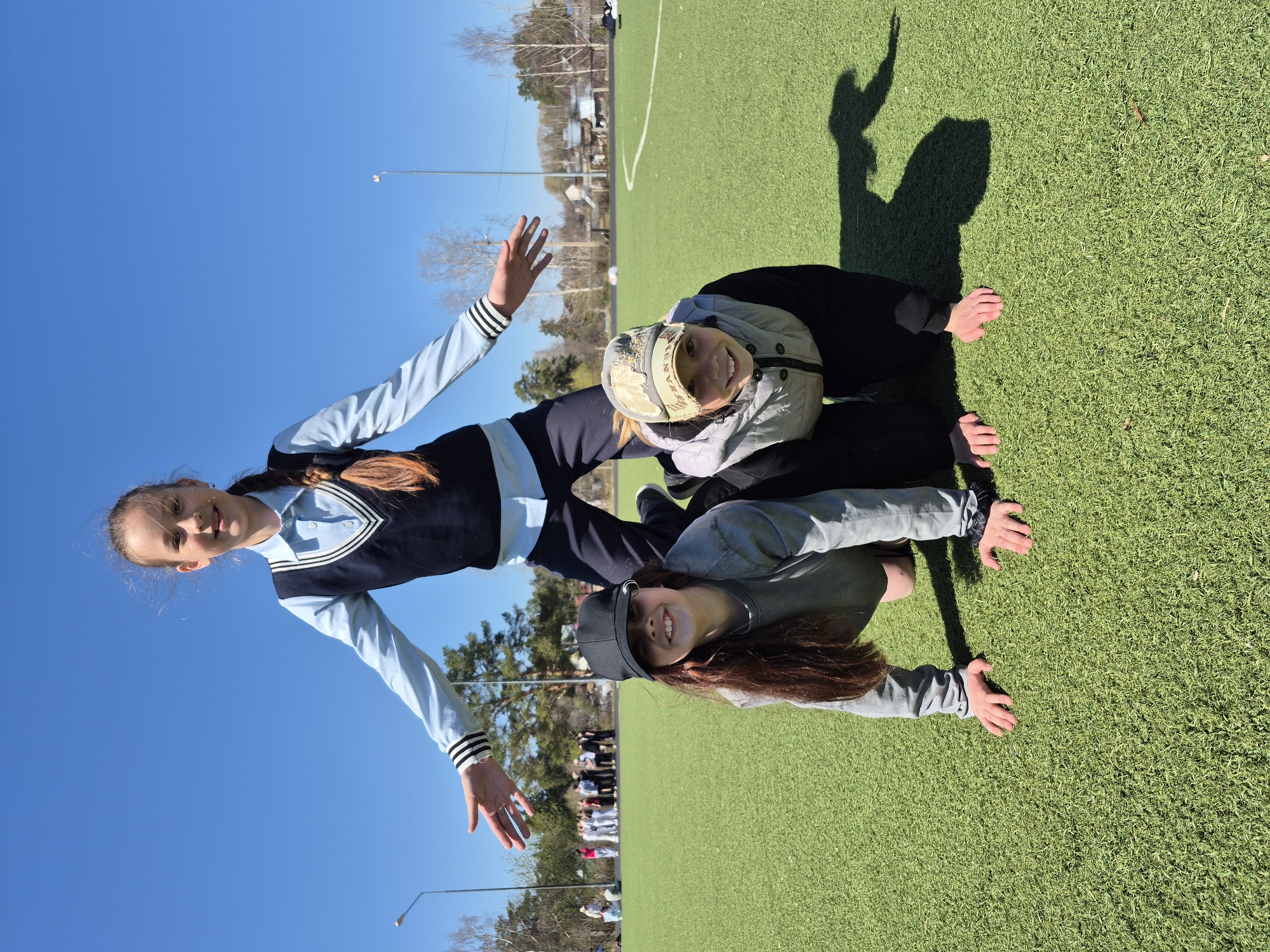 Schoolgirls play and pose on sports field in Chaikovsky