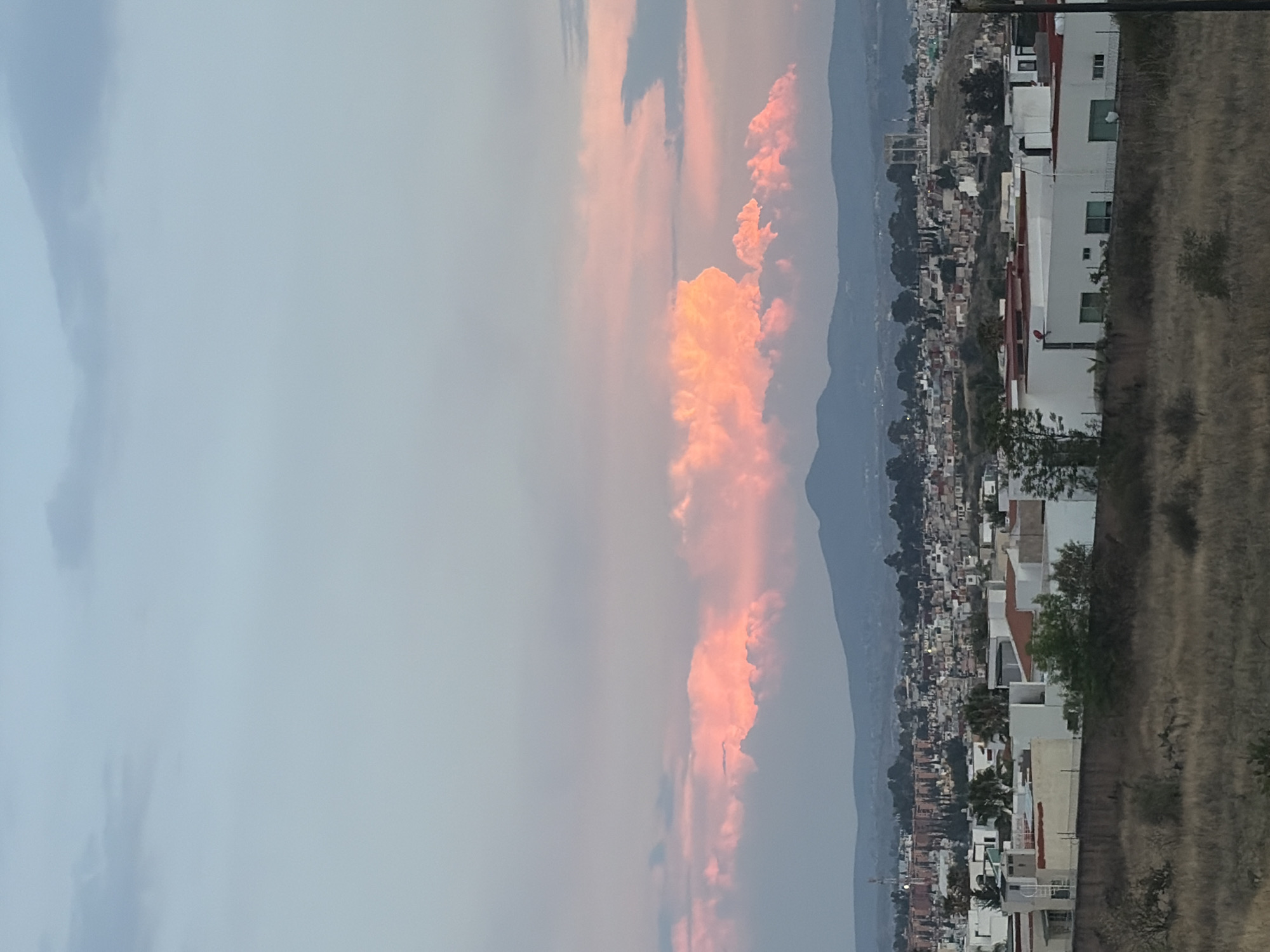 City skyline documented against mountain backdrop during evening hours