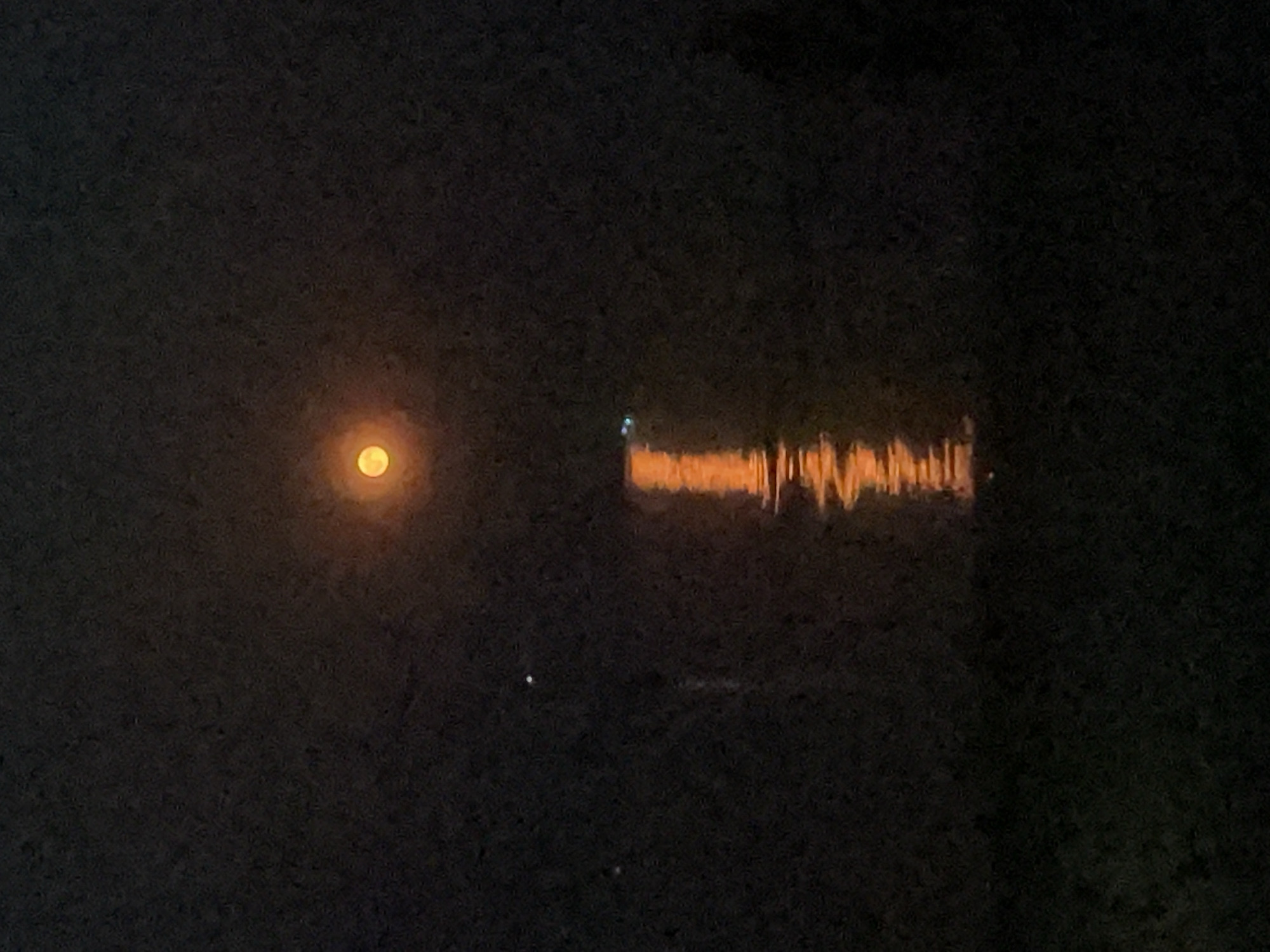 Full moon over water and campfire on a Constance summer night