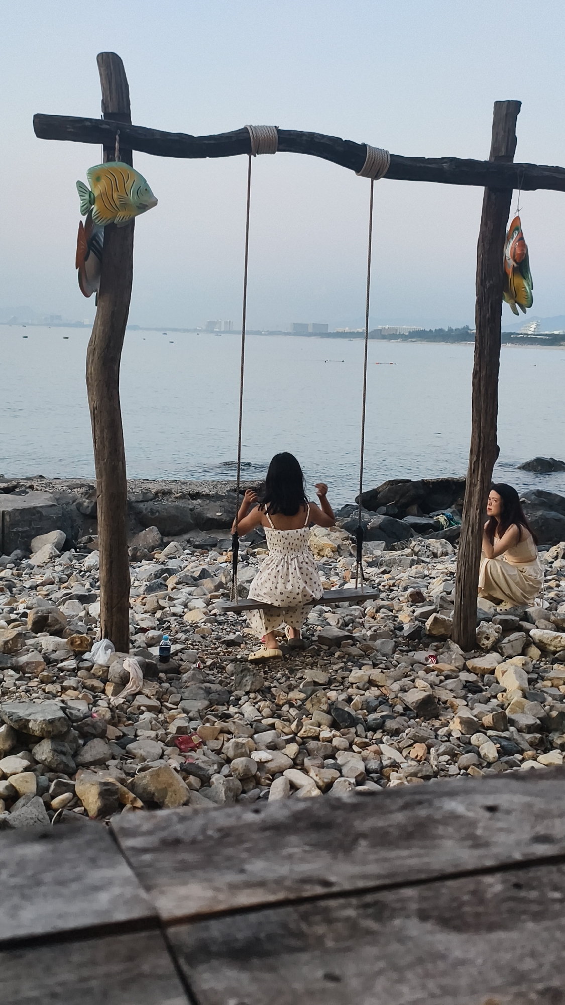 Paddleboarding and a rocky shore swing at sunset