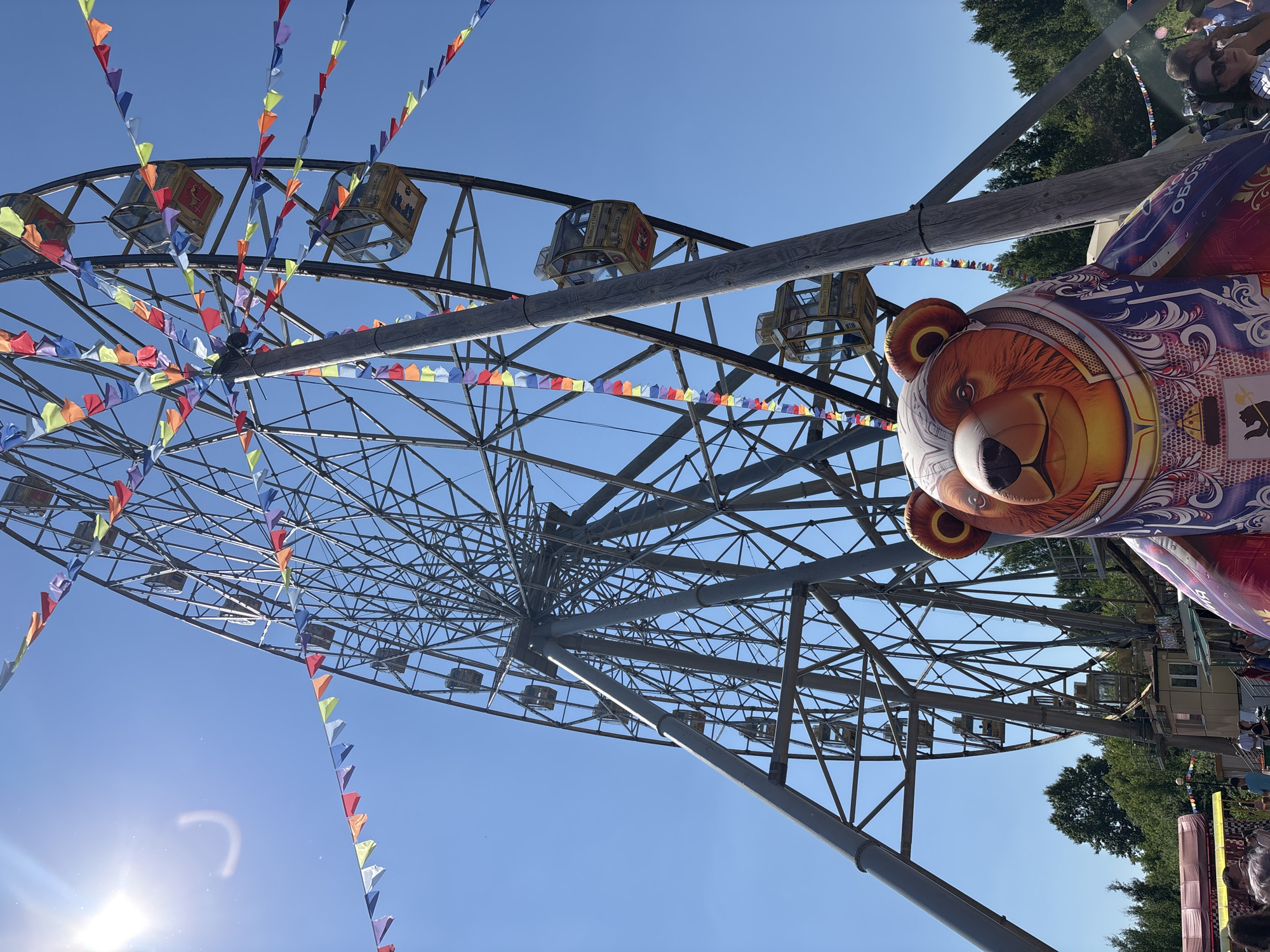 Ferris wheel operates with decorative flags in Rusanovo, Russia