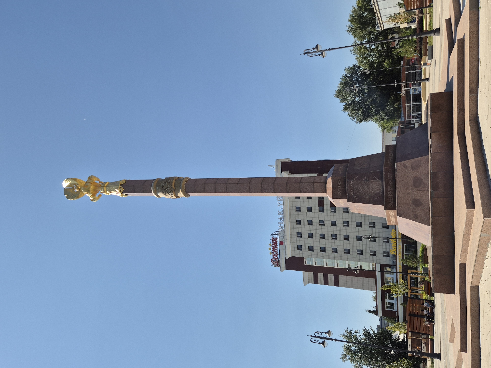 Sunny morning at a Kokshetau public square with monument and fountain