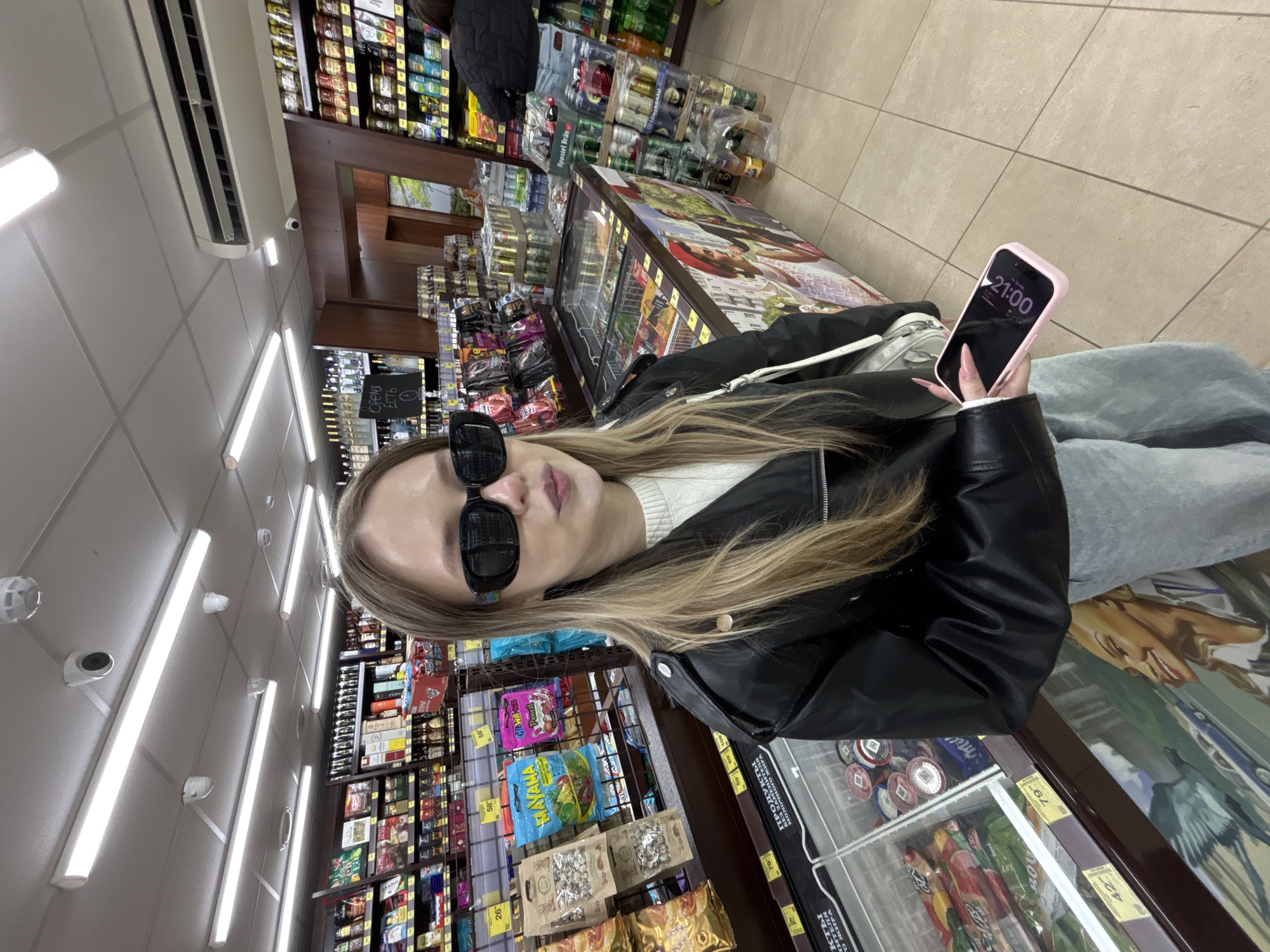 Young women pose for photos in Фоки convenience store