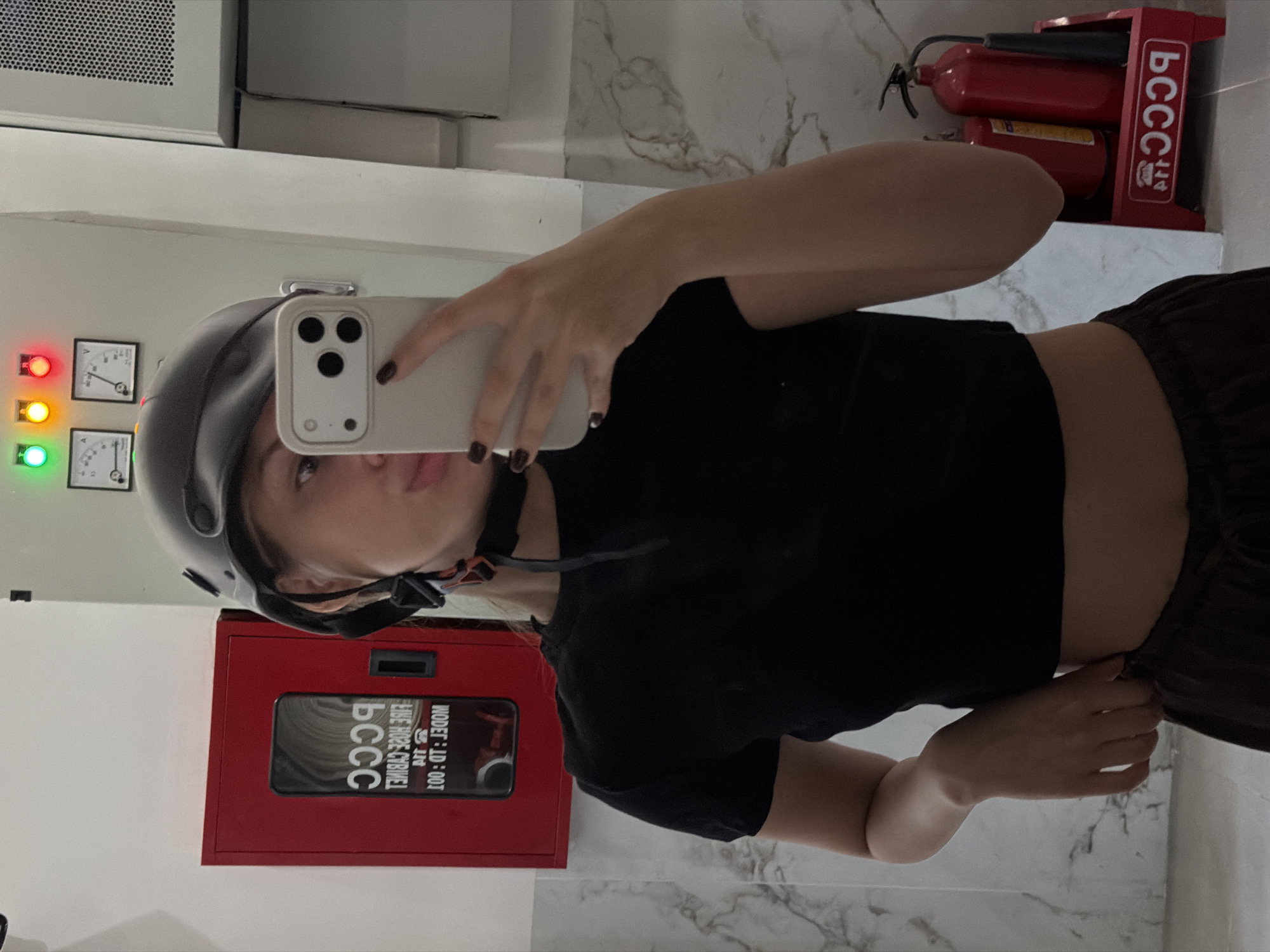 Mirror selfie in a Đà Nẵng entryway with scooters nearby