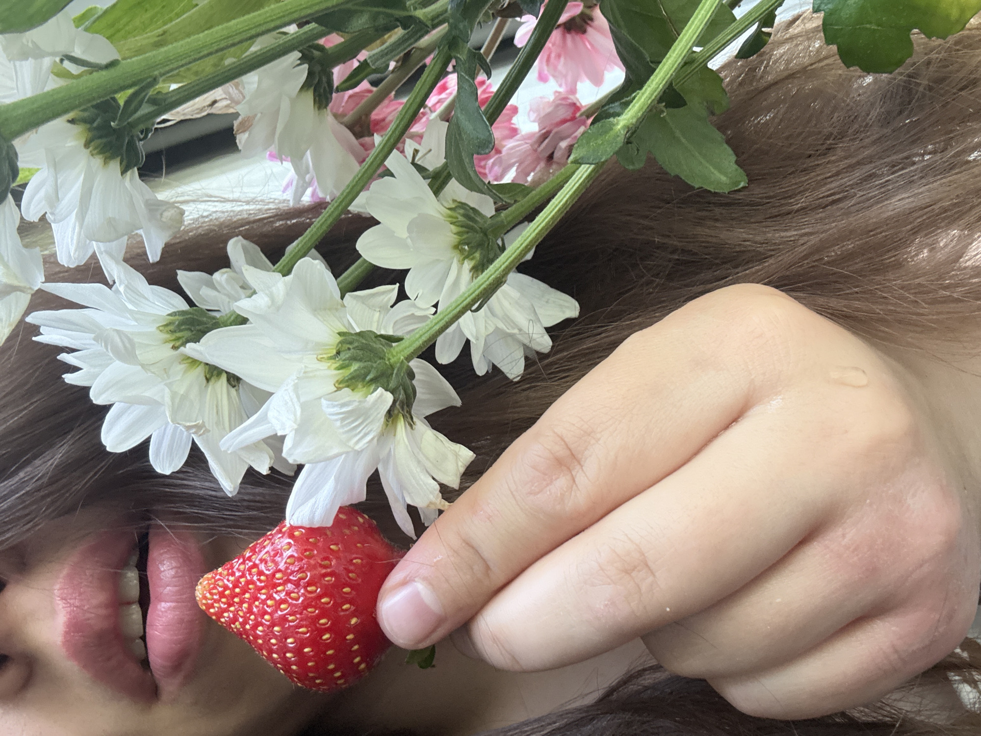 Person enjoys fresh strawberries and flowers in Krasnoyarsk morning