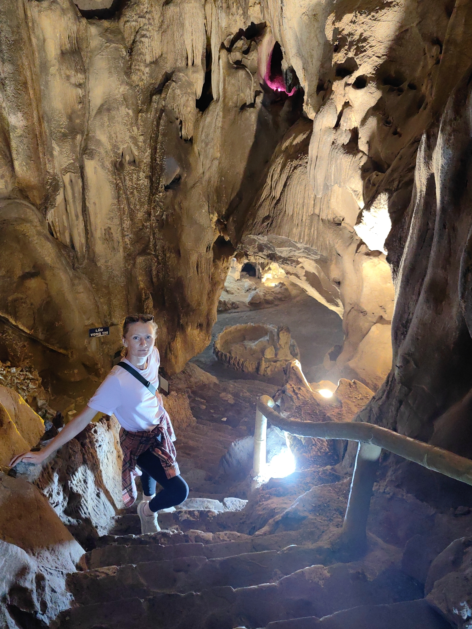 Tourist explores and photographs cave interior in Quảng Lạc