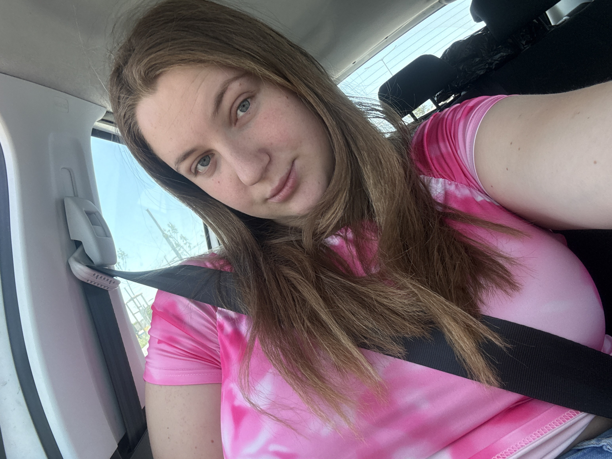 Driver in pink tie-dye waits at red light