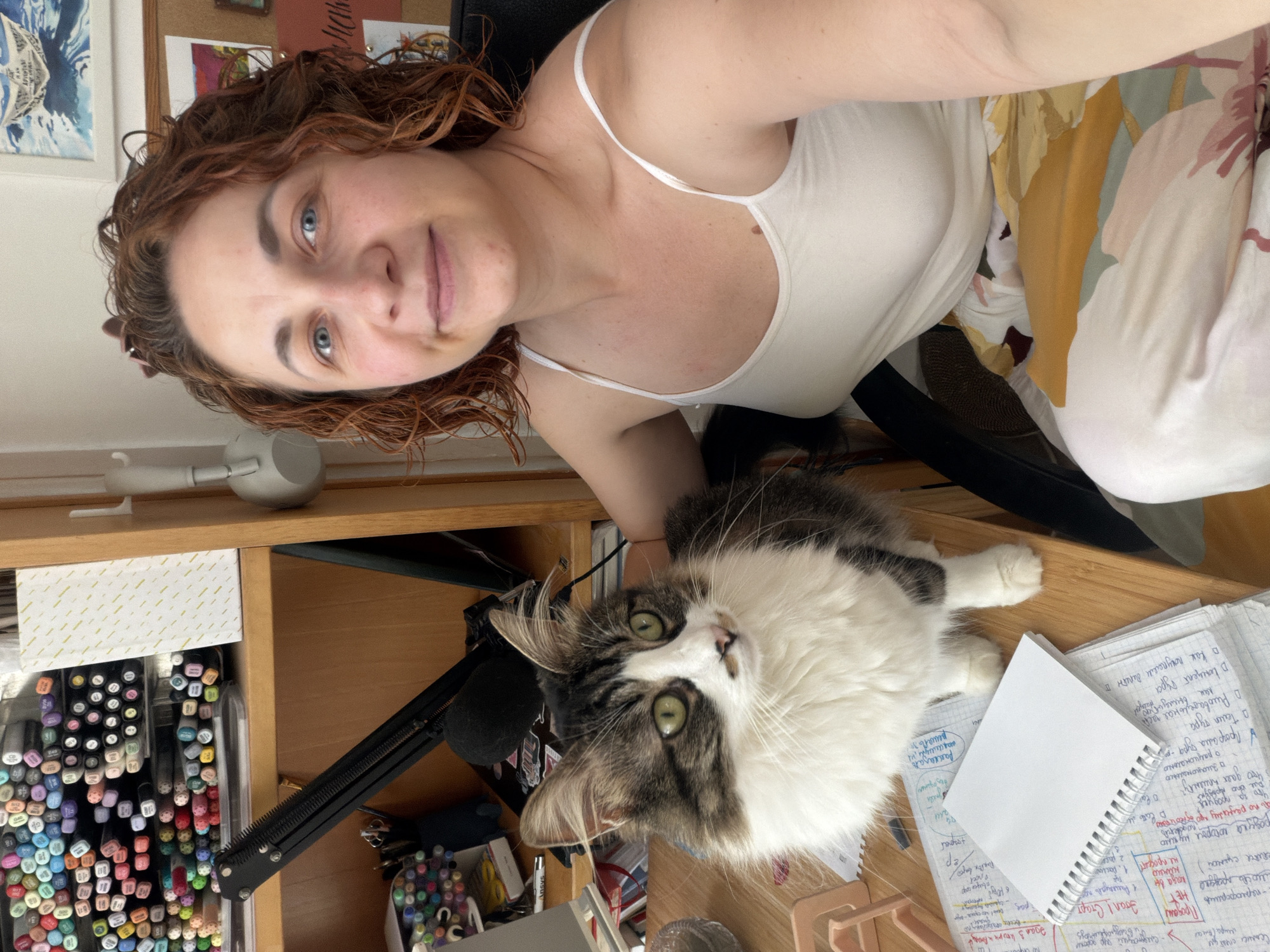 Woman takes selfie with cat at art desk in Bat Yam