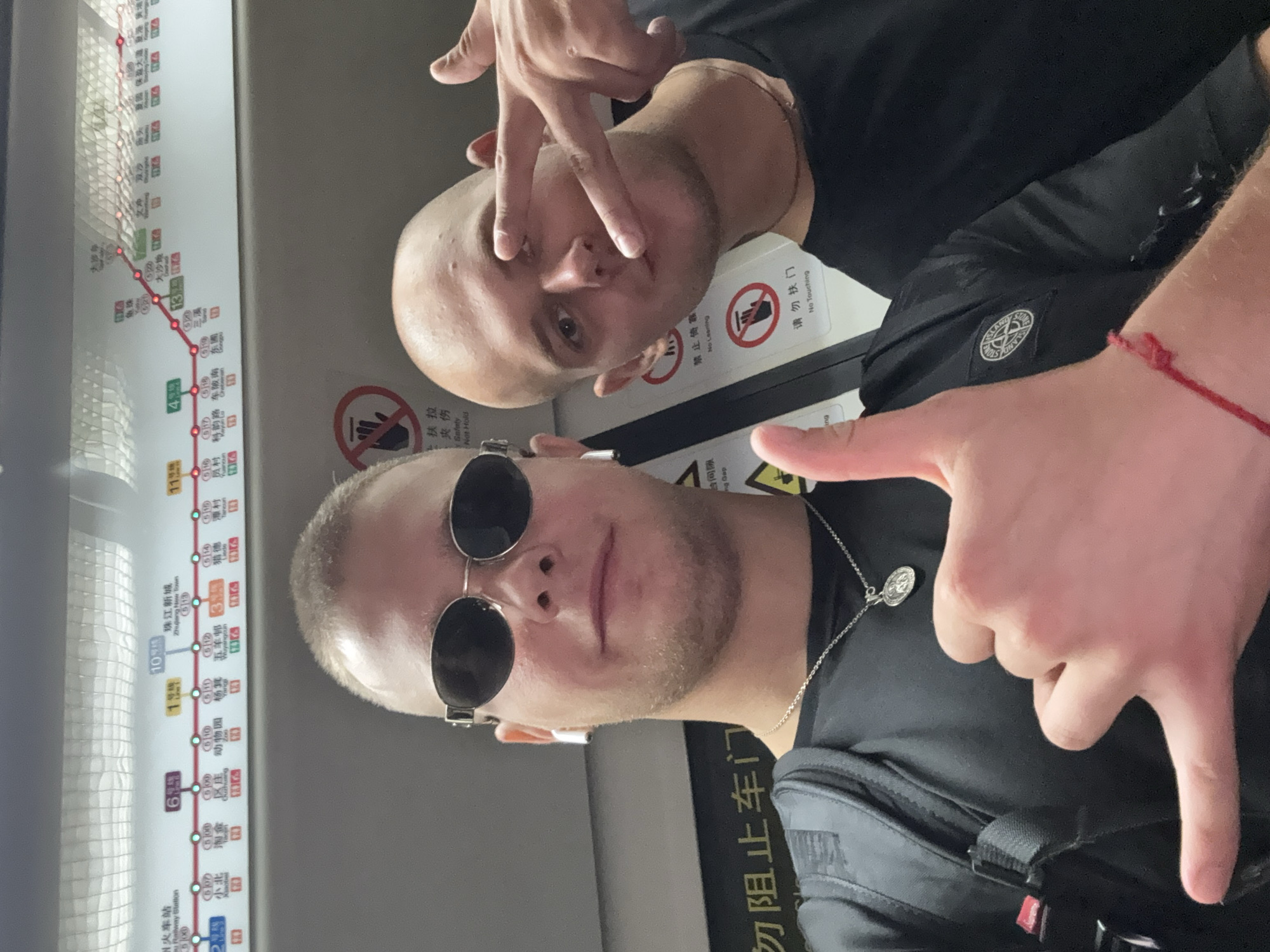 Two tourists take selfies on crowded Panyu subway train