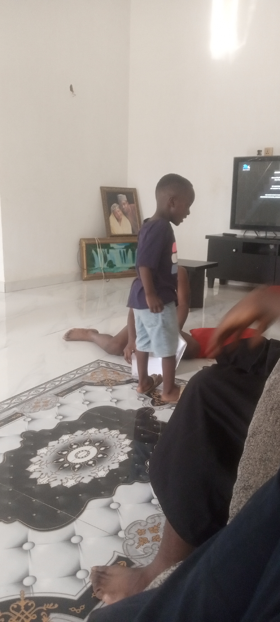 Child observed standing near person lying on floor indoors