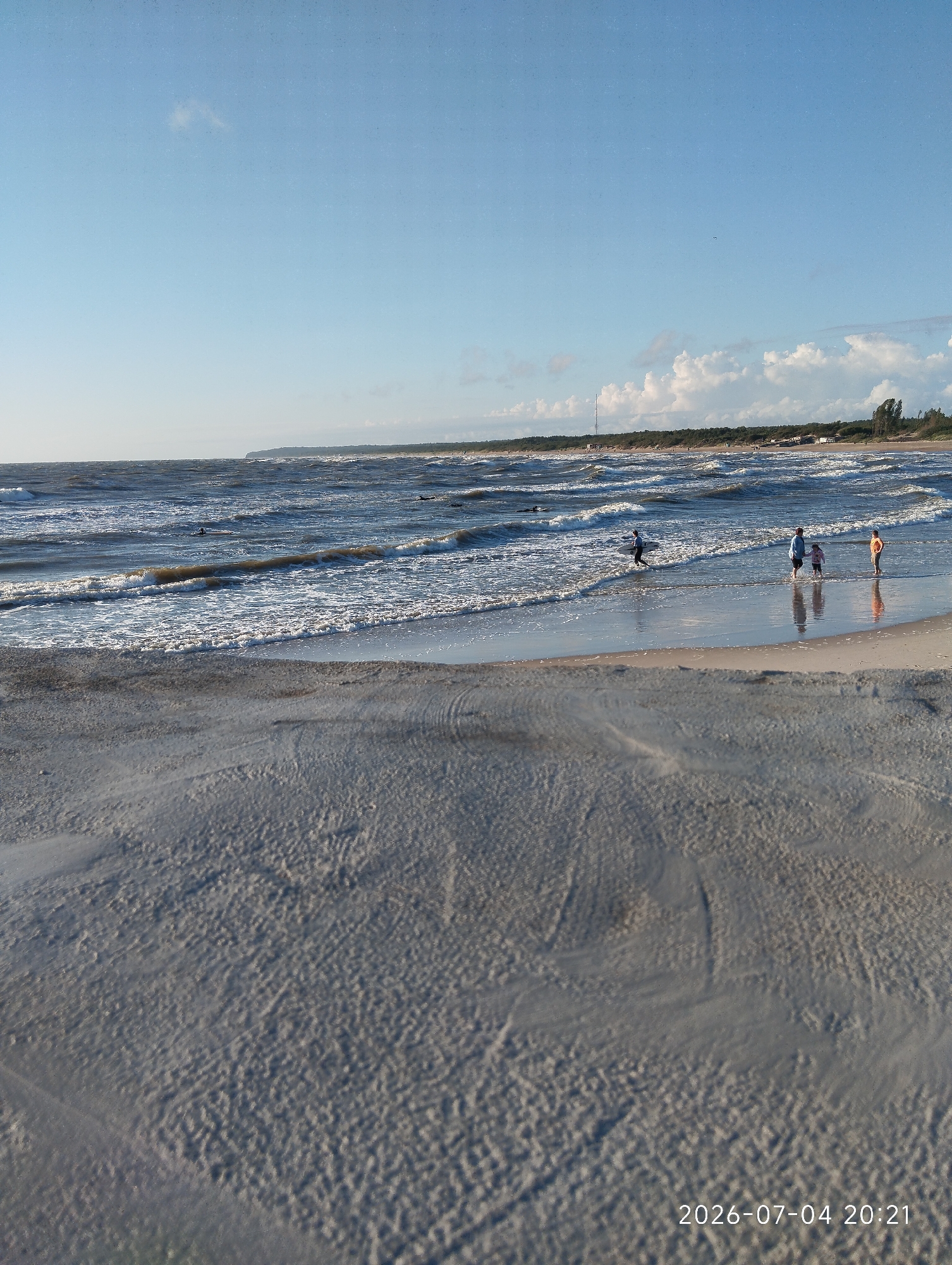 Surfing and swimming on a choppy Baltic Sea afternoon