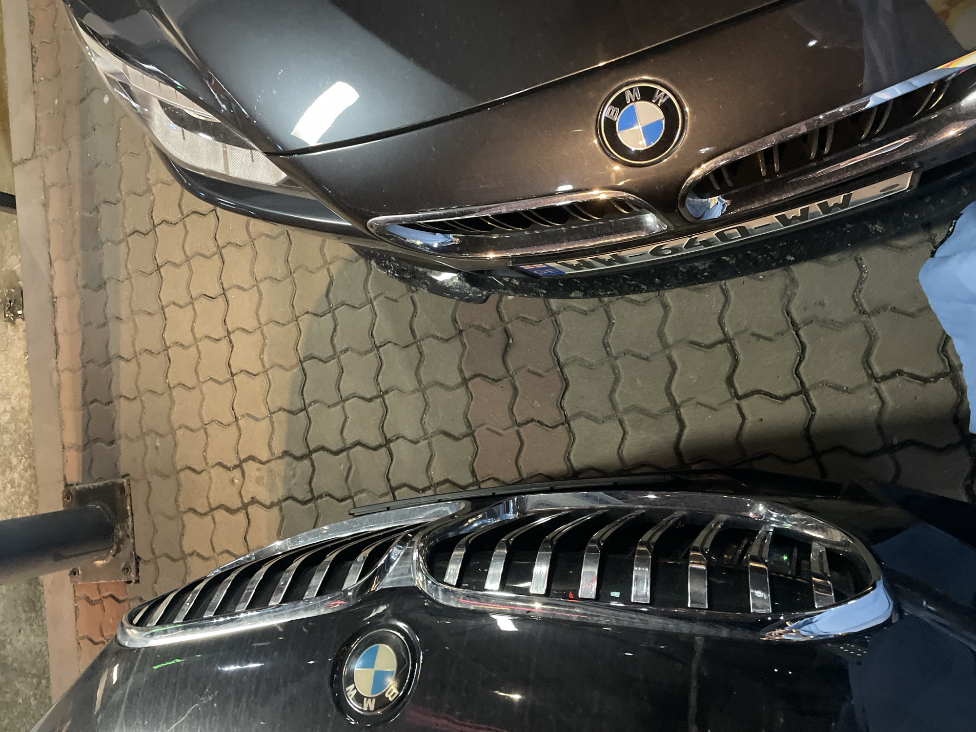 BMW cars parked near illuminated modern building in Batumi
