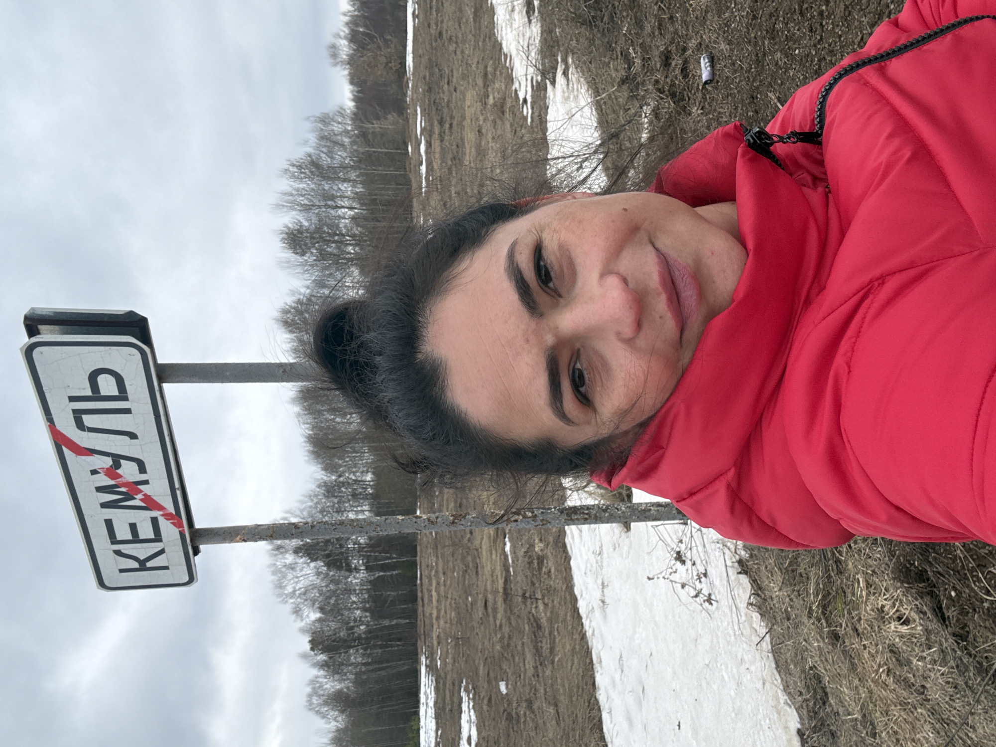 Woman photographed at Kemul city sign during early spring