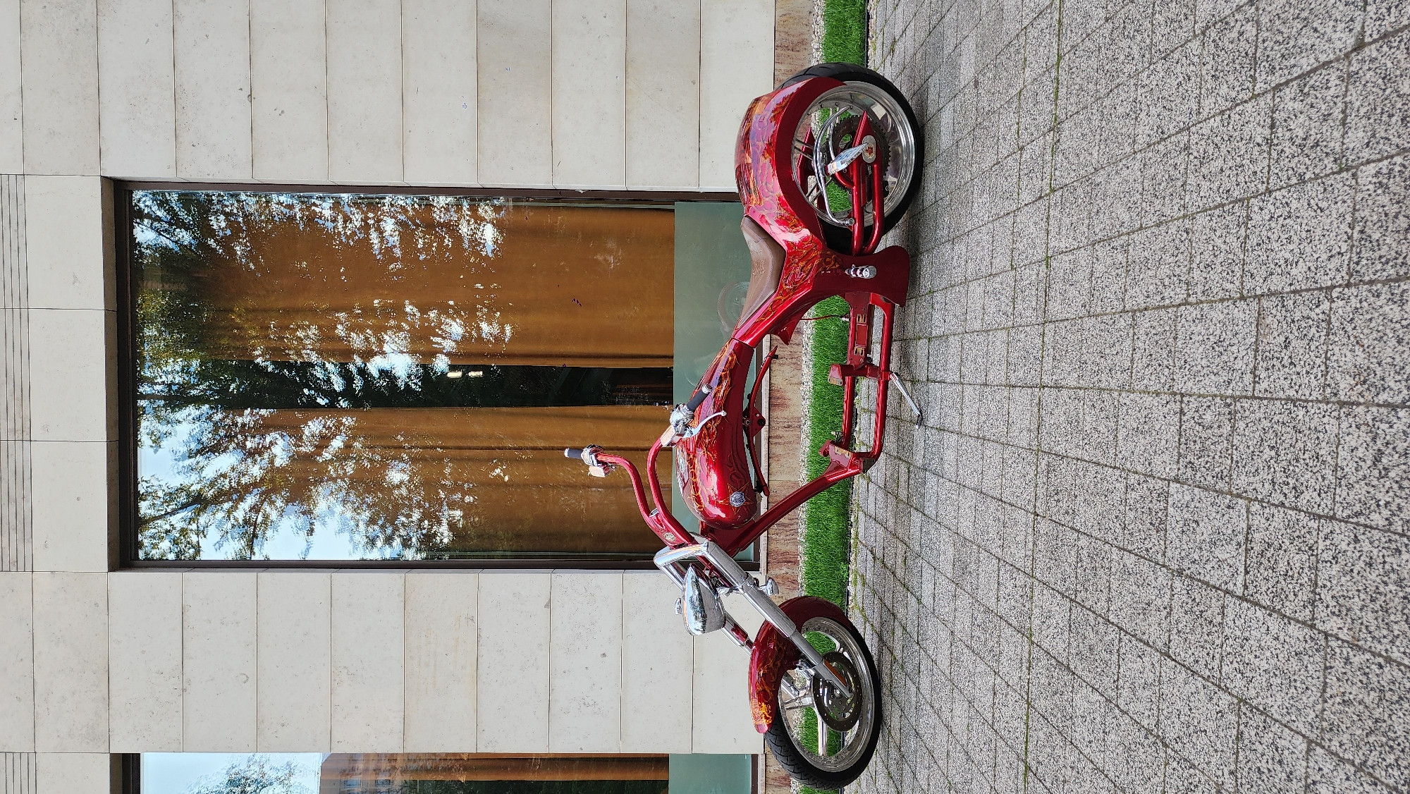 Custom red chopper parked near Moscow's modern waterfront district