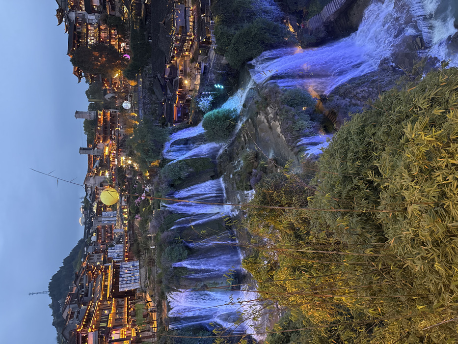Tourist documents evening visit to illuminated Furong Ancient Town