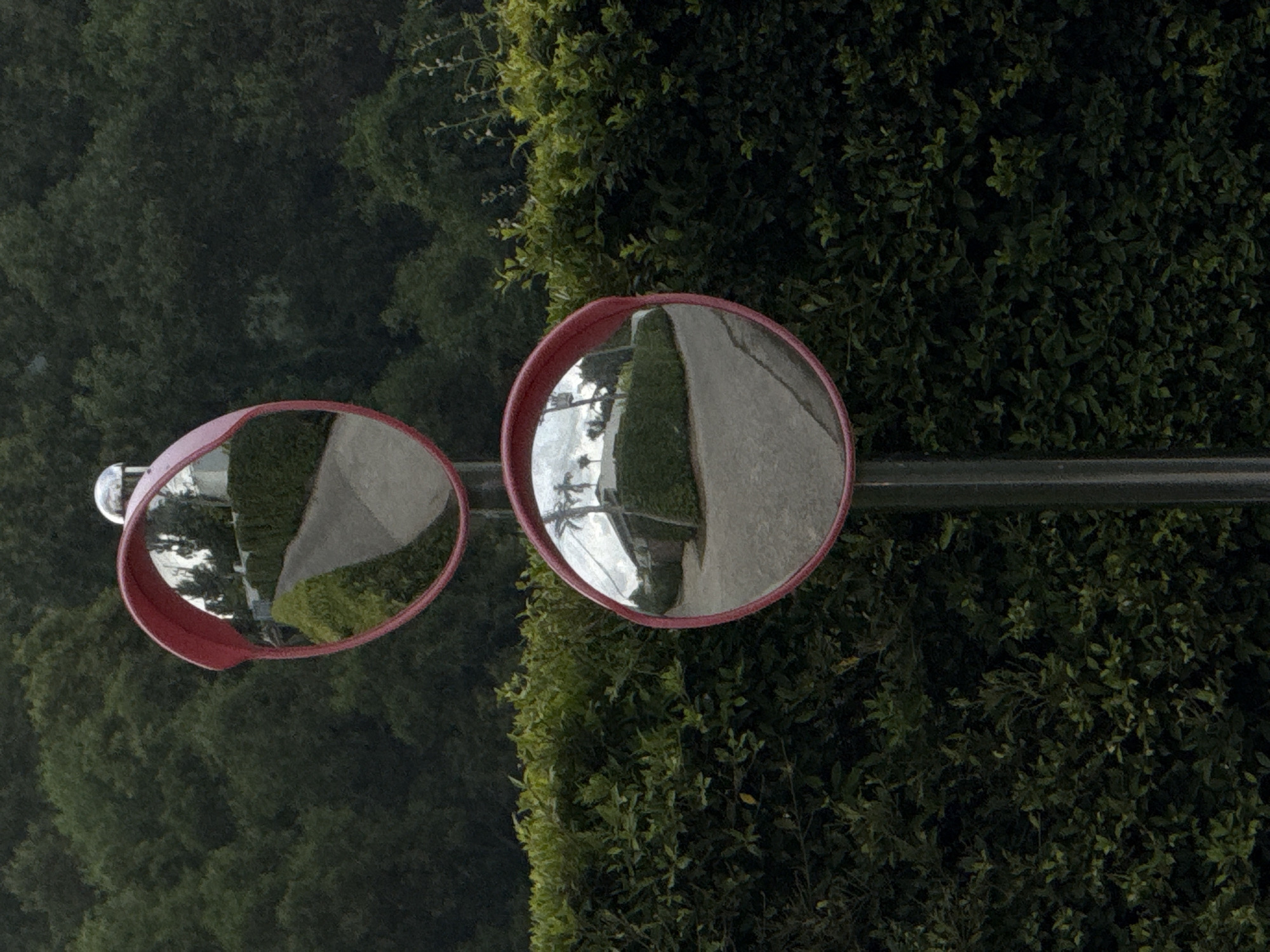 Safety mirrors, a scooter, and yard cleanup on a cloudy Phuket morning