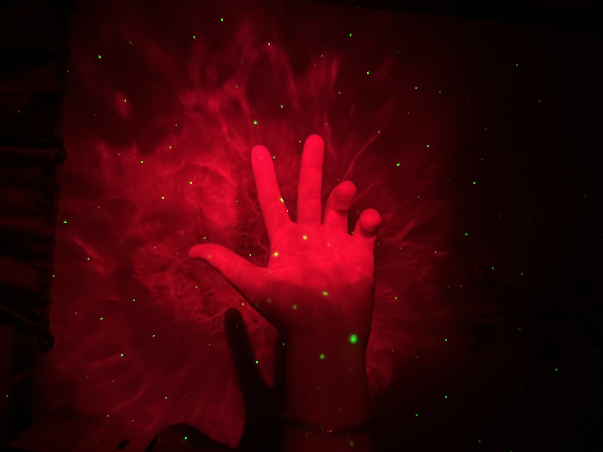 Hands play in projected nebula light at a Saint Petersburg installation