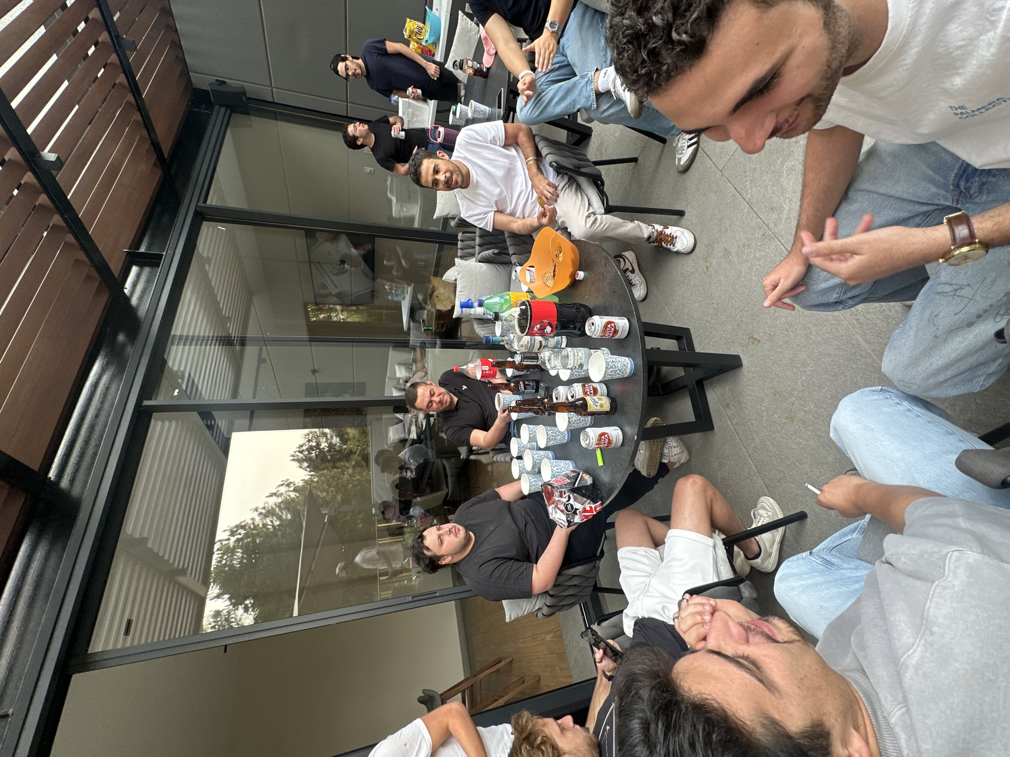Nine young men gather around table in Mexican patio