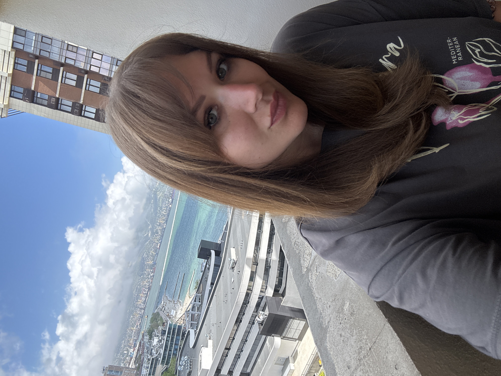 Woman observed on balcony overlooking Novorossiysk cityscape