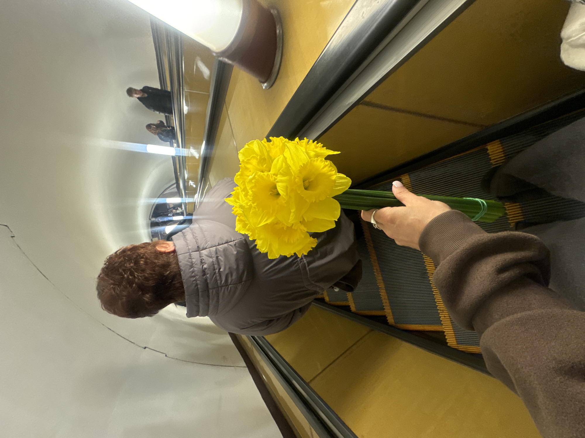 Spring flowers carried on Moscow escalator