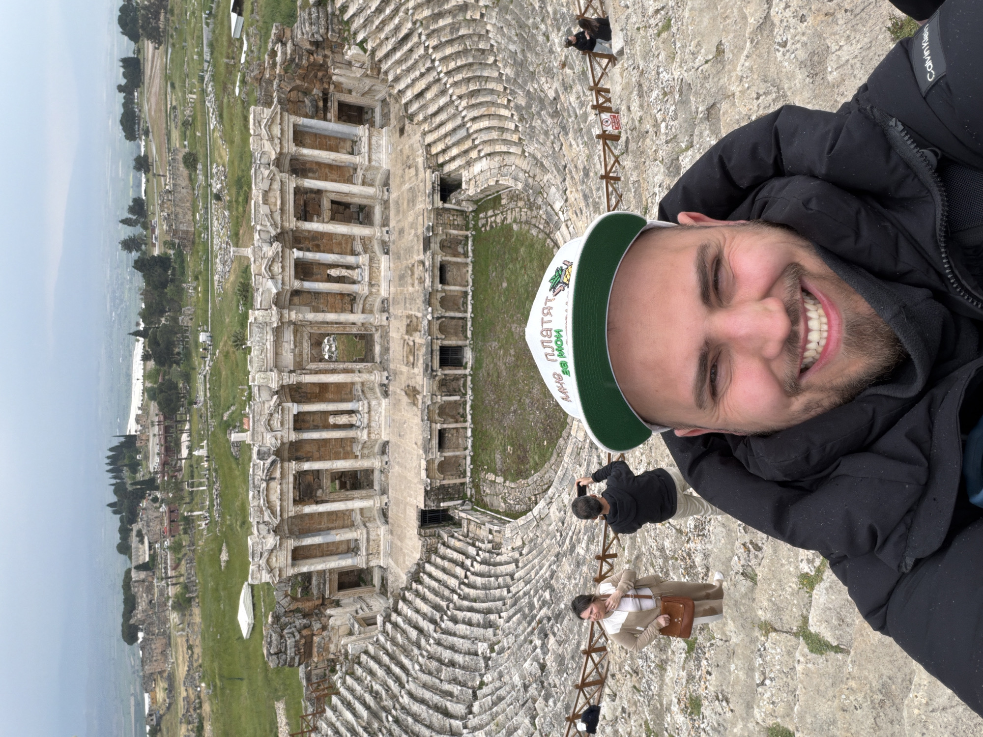 Tourist visits ancient Hierapolis theater, paraglider spotted over Pamukkale