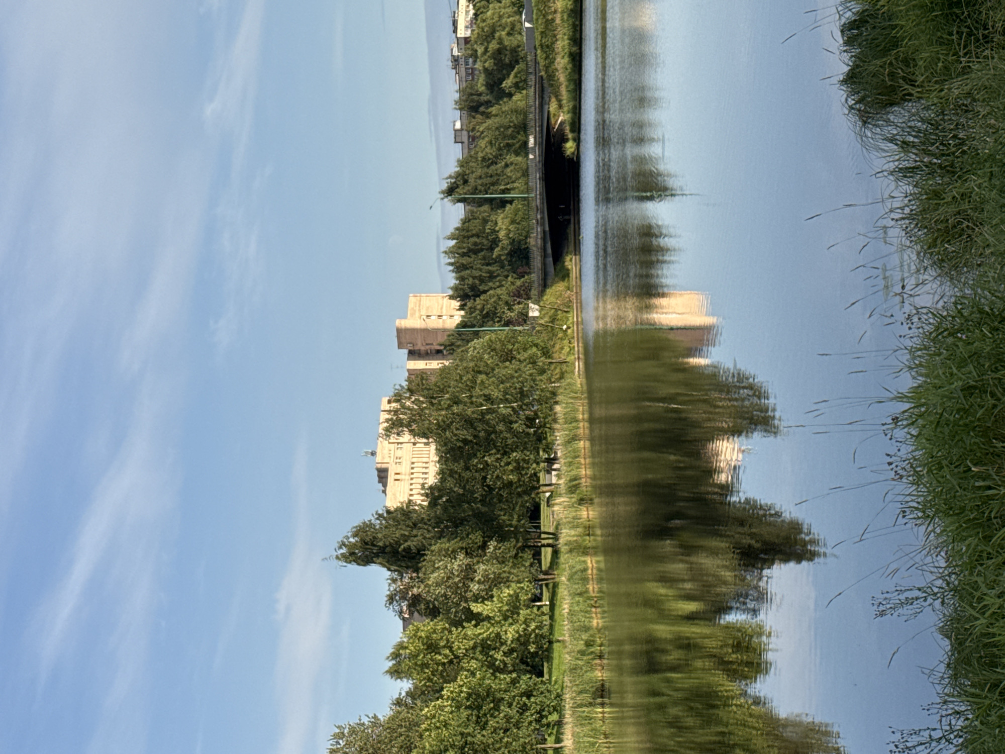 Still water mirrors a clear sky at a quiet Russian waterfront