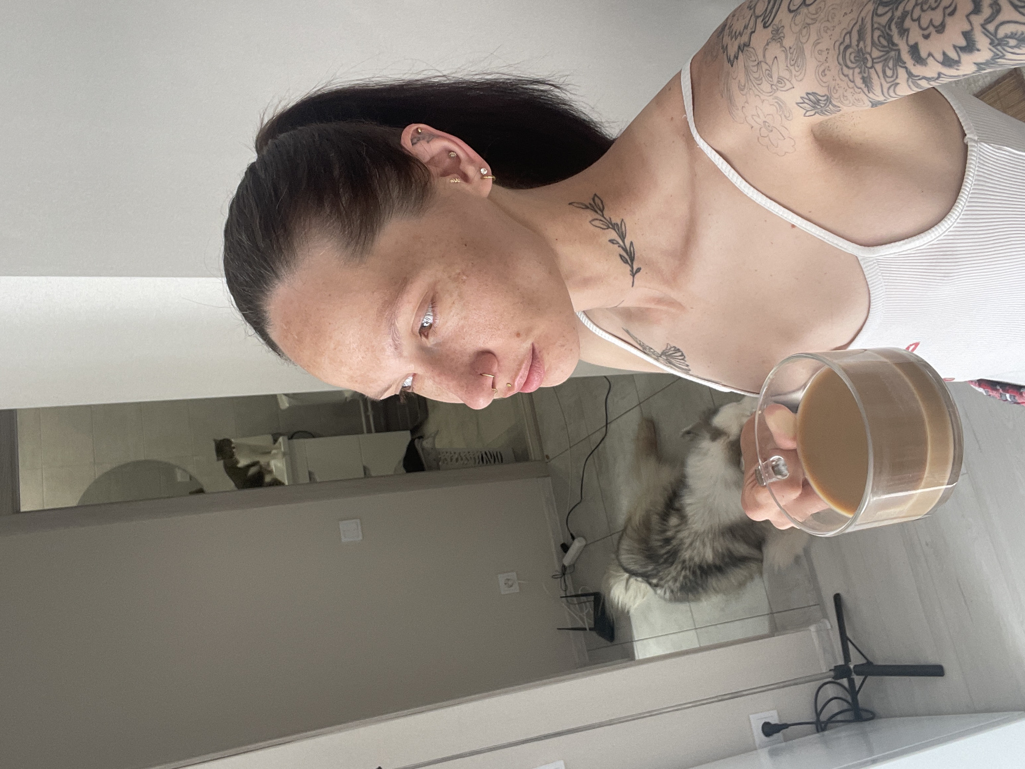 Woman with coffee, cat on windowsill captured in Izhevsk